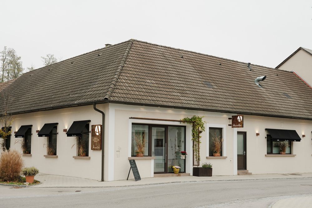 Modern restaurant building decorated with signs and plants.