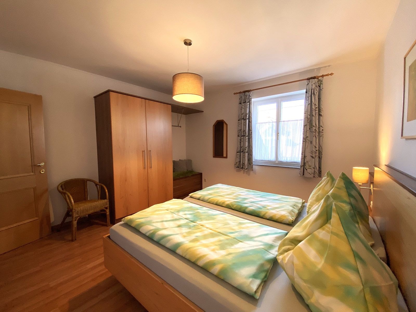 Bedroom with double bed, closet, chair and window.