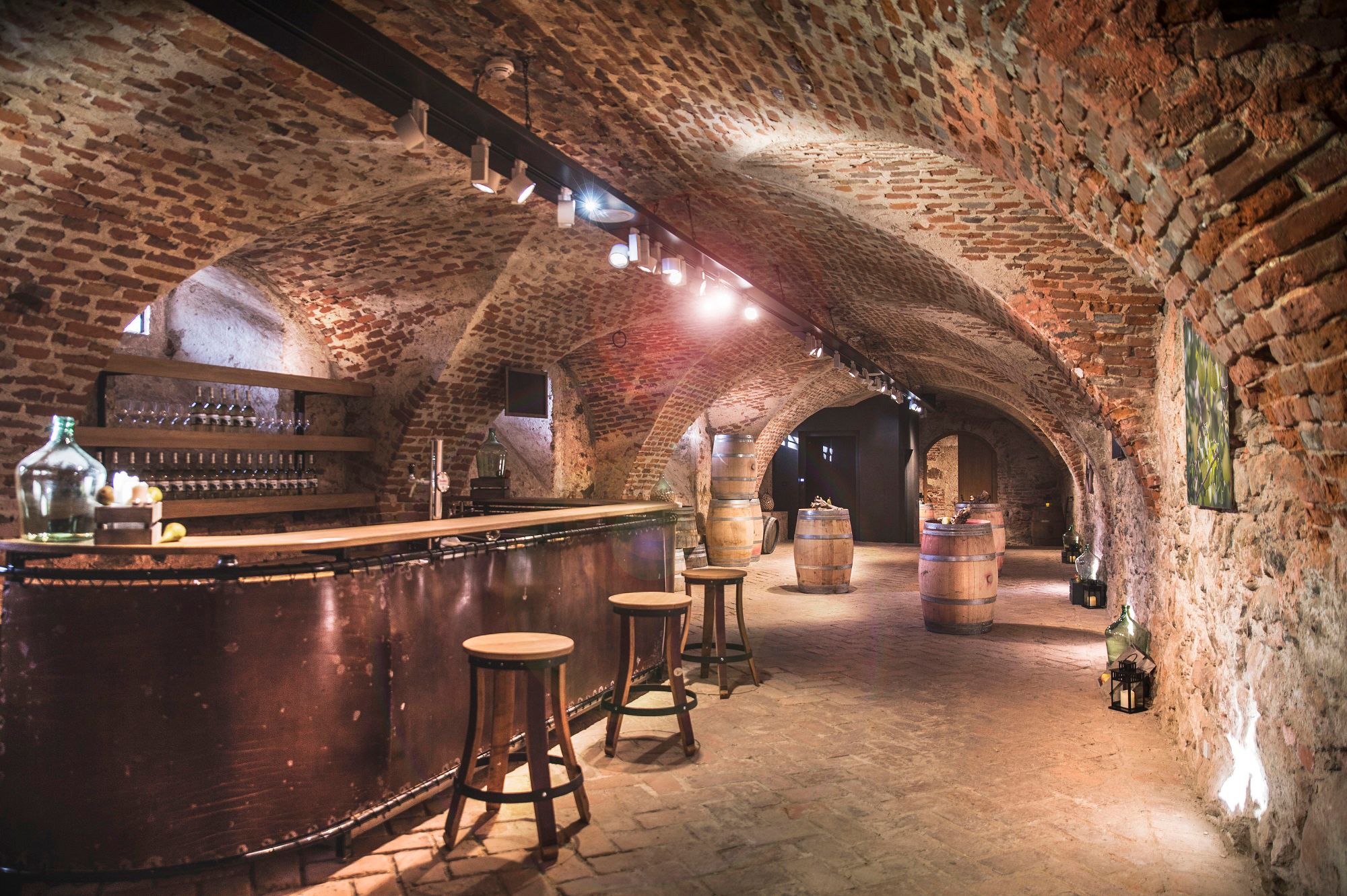 Historic castle cellar with brick walls, bar and wooden barrels.