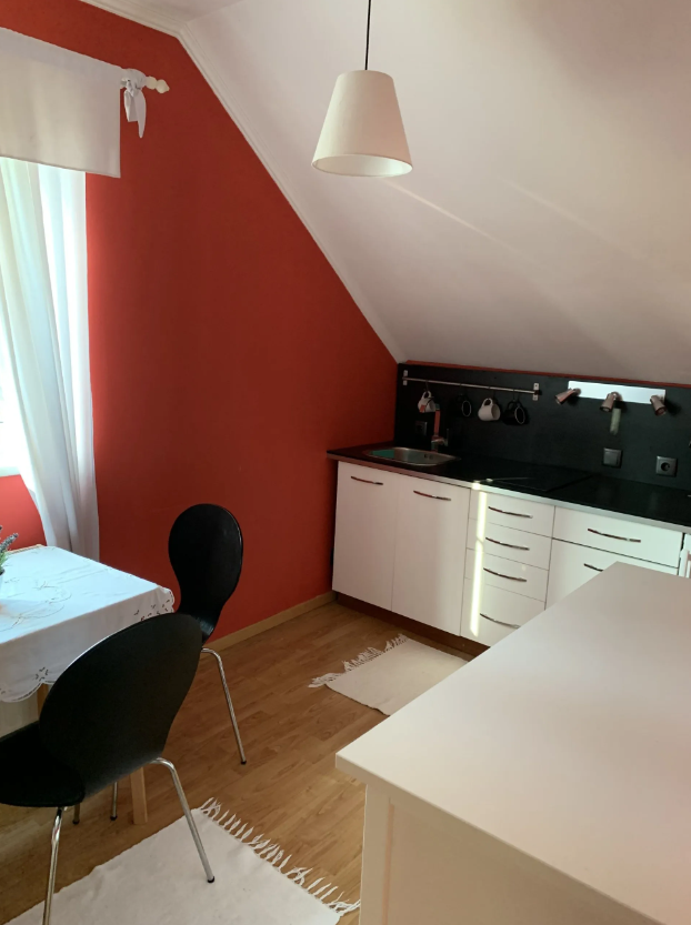Kitchen unit with sink and black worktop with small seating area