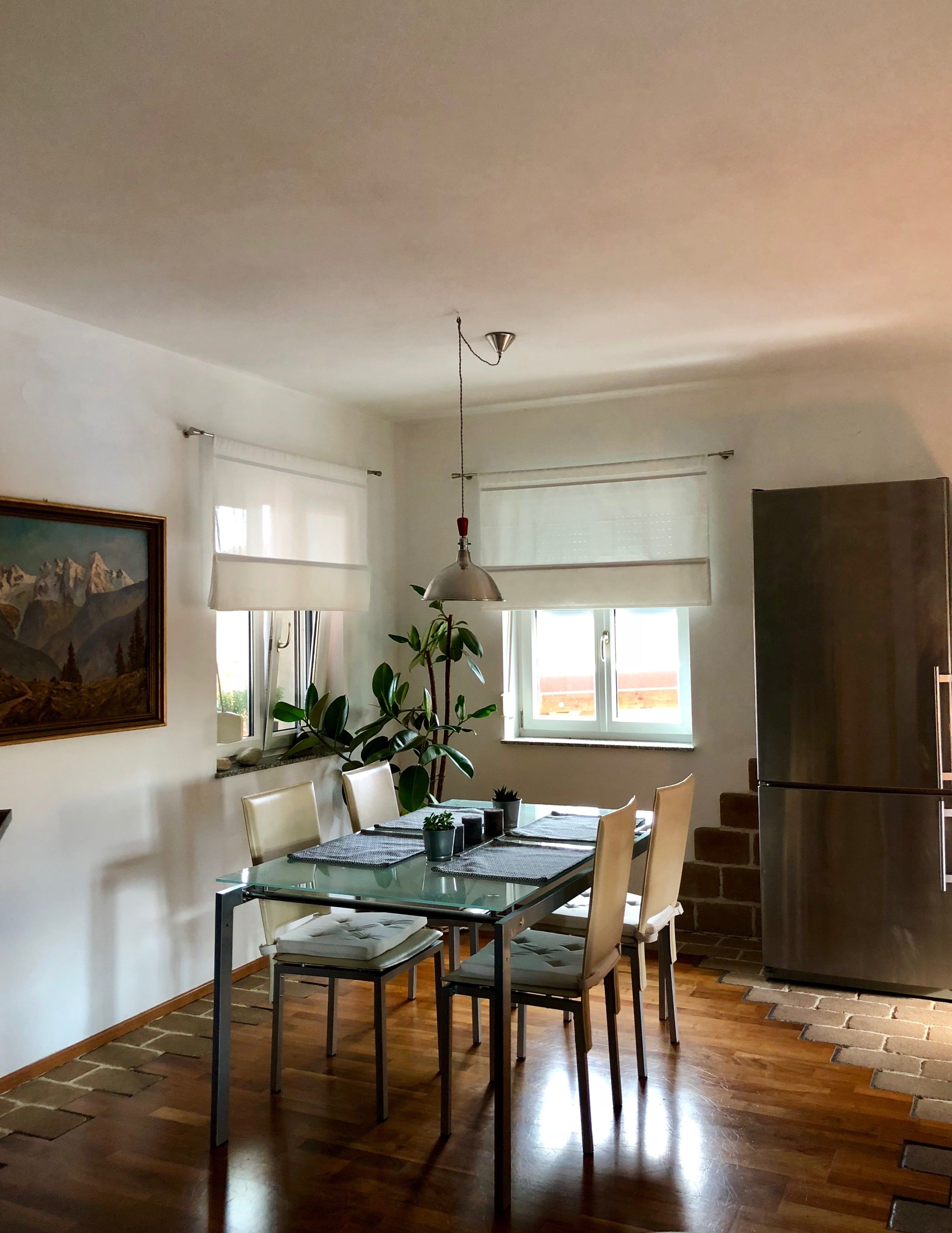 Open-plan living and dining area with table, chairs and natural light.