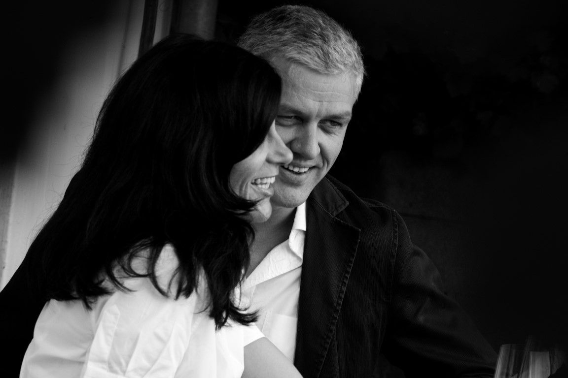 Black and white photo of a smiling couple close to each other.