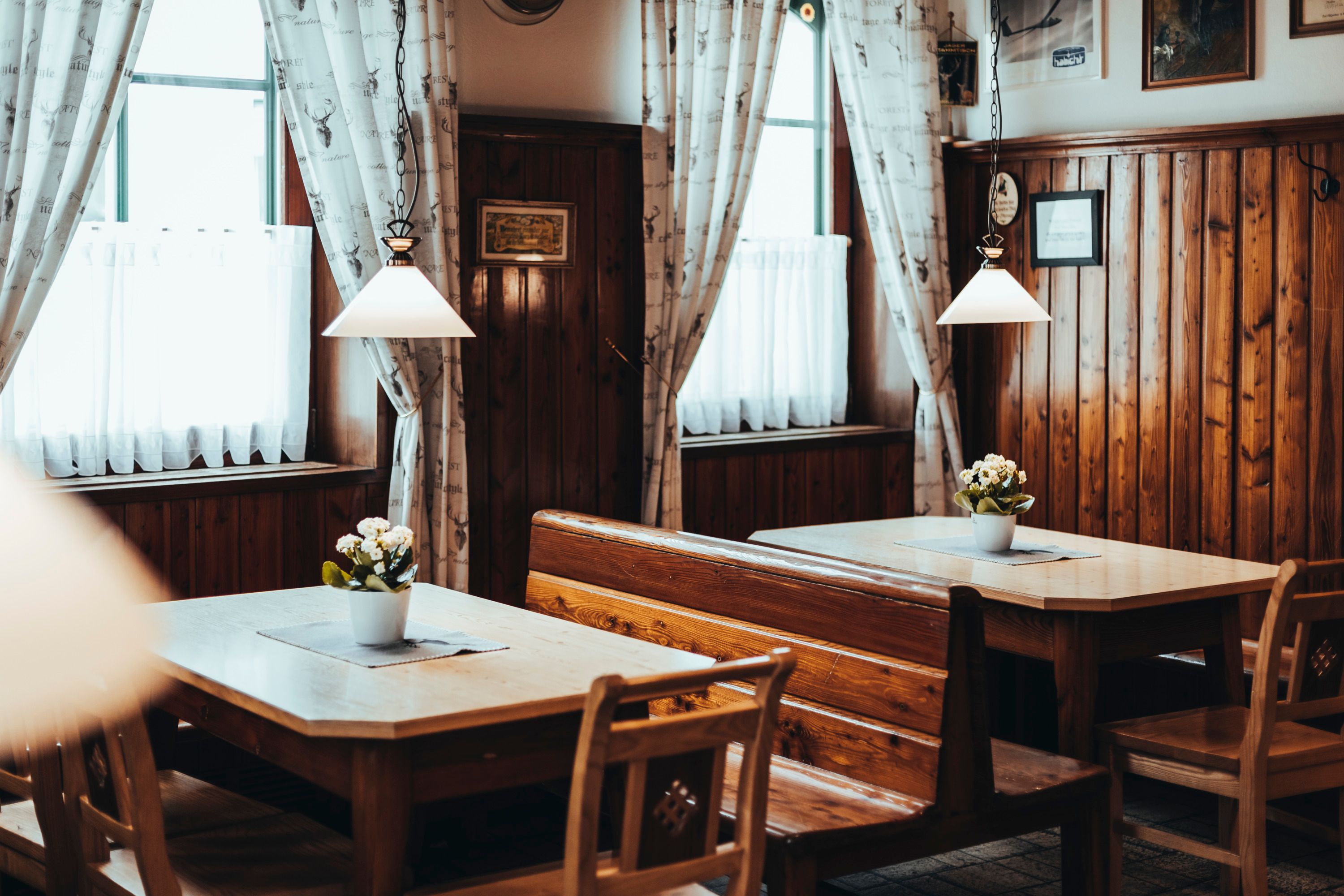 Cozy, rustic restaurant with wooden furniture and flowers on the tables.