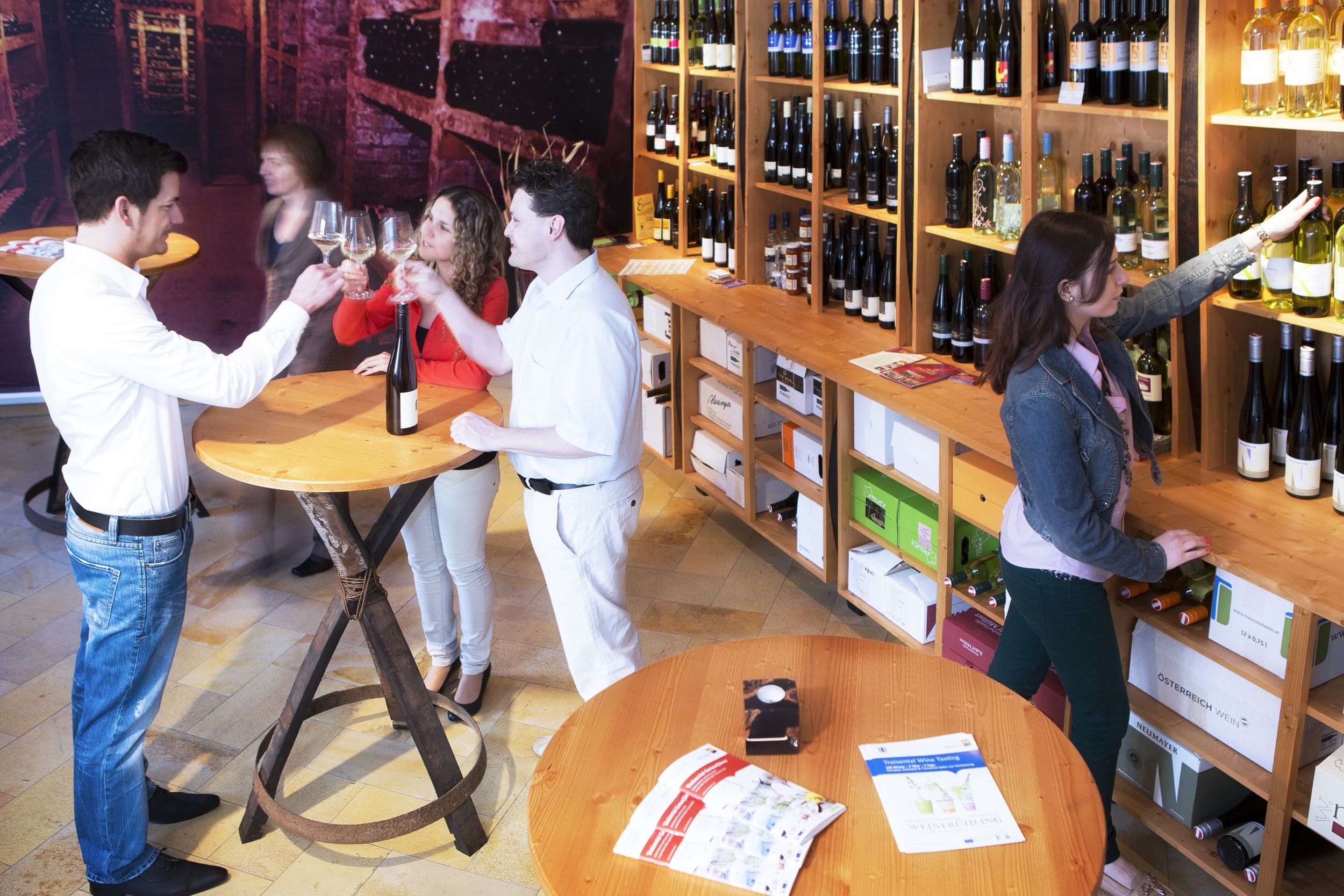 People in a wine store tasting wine and selecting bottles.