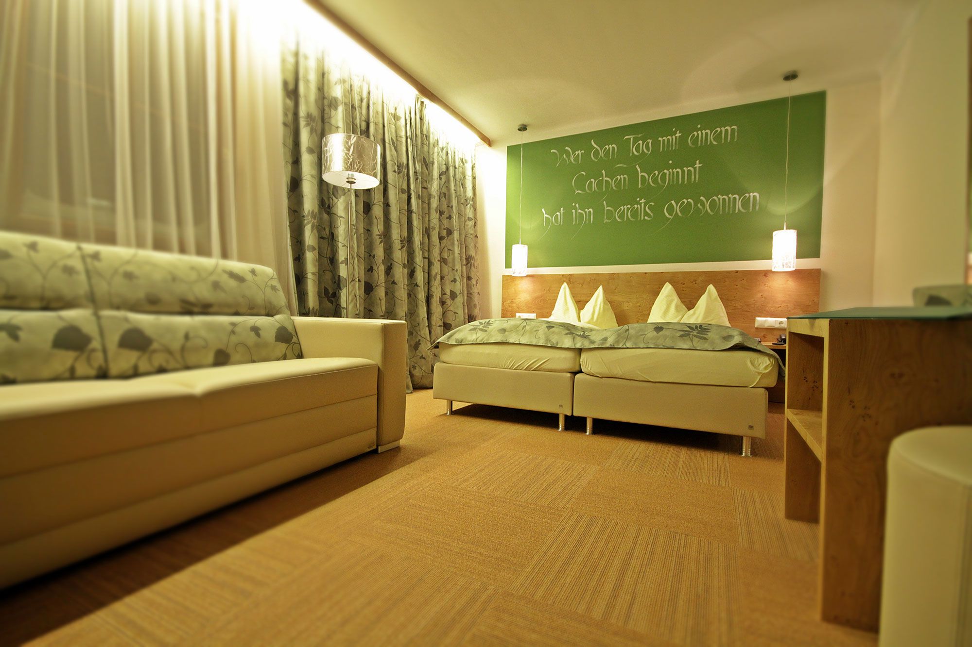 Cozy guest room with double bed, sofa and decorative curtains.