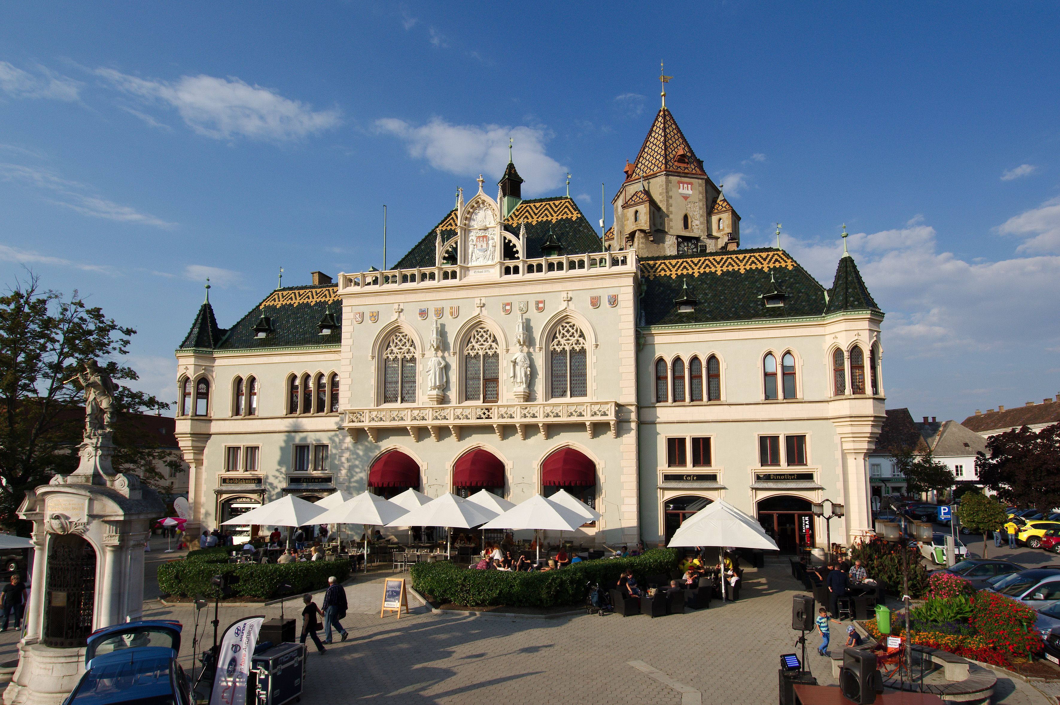 Korneuburg town hall with striking architecture and sunshades in the foreground.