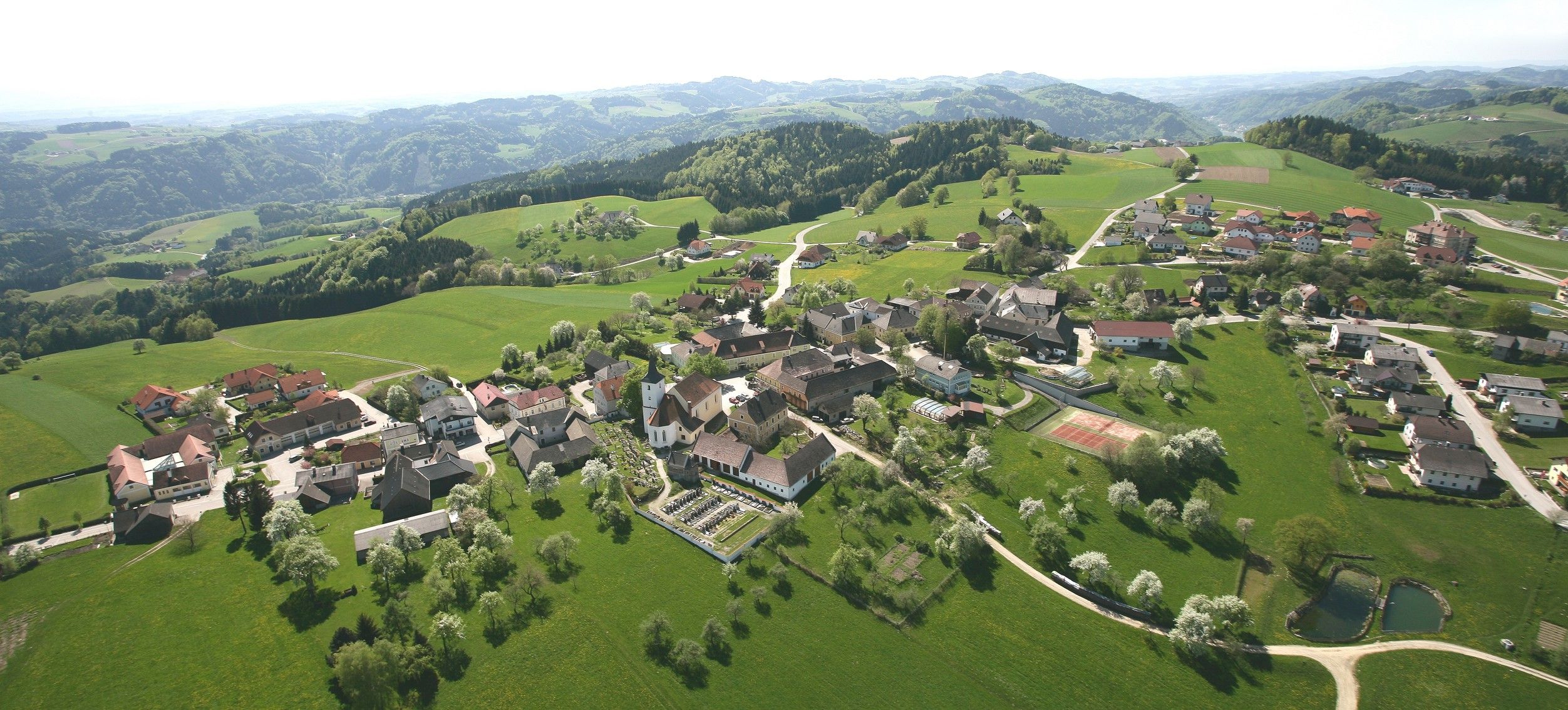 Aerial view of the municipality of Nöchling with green fields and hills.