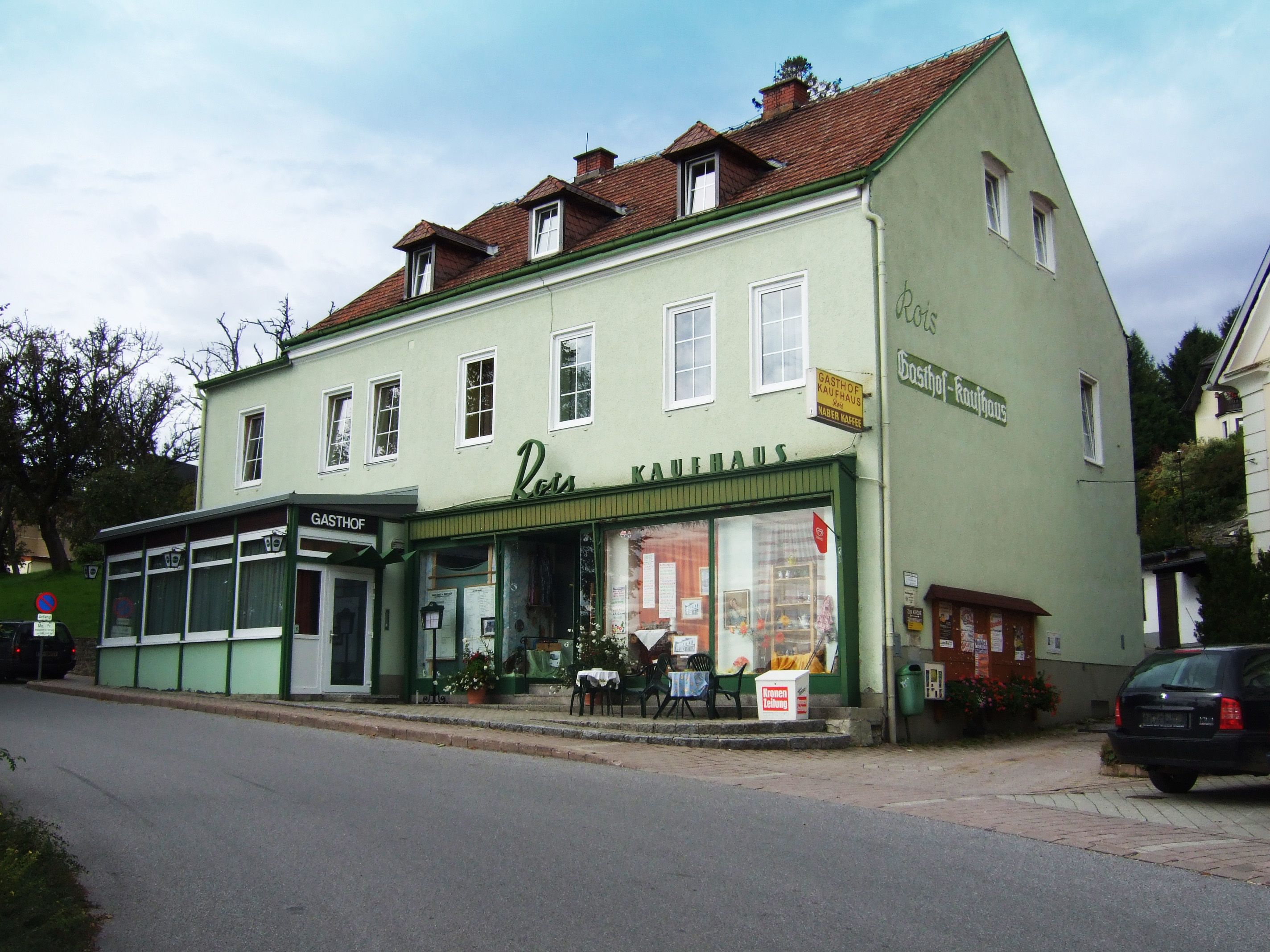 Green building with the inscription 'Gasthof Rois'.