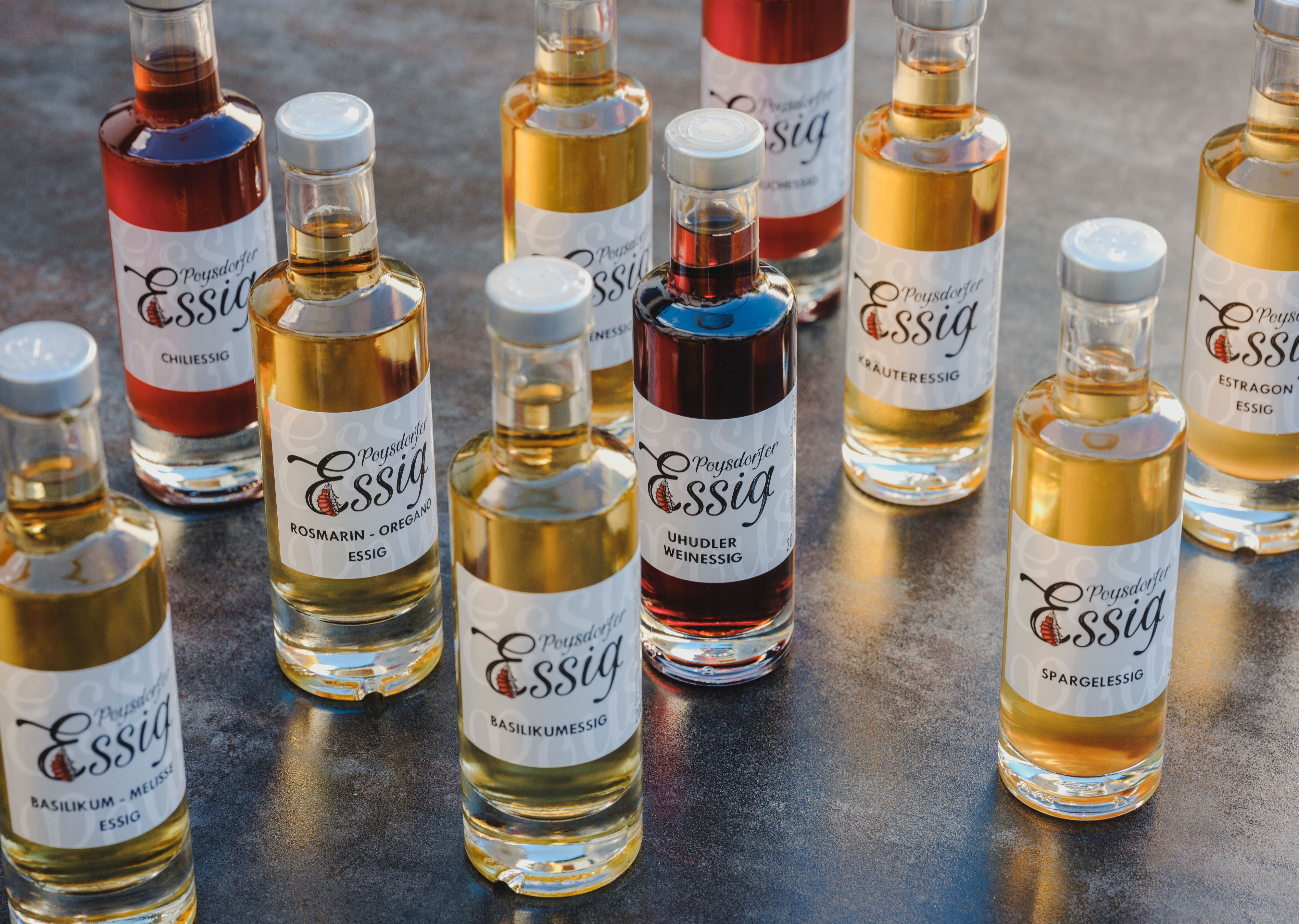 Various bottles of Poysdorf vinegar on a table.