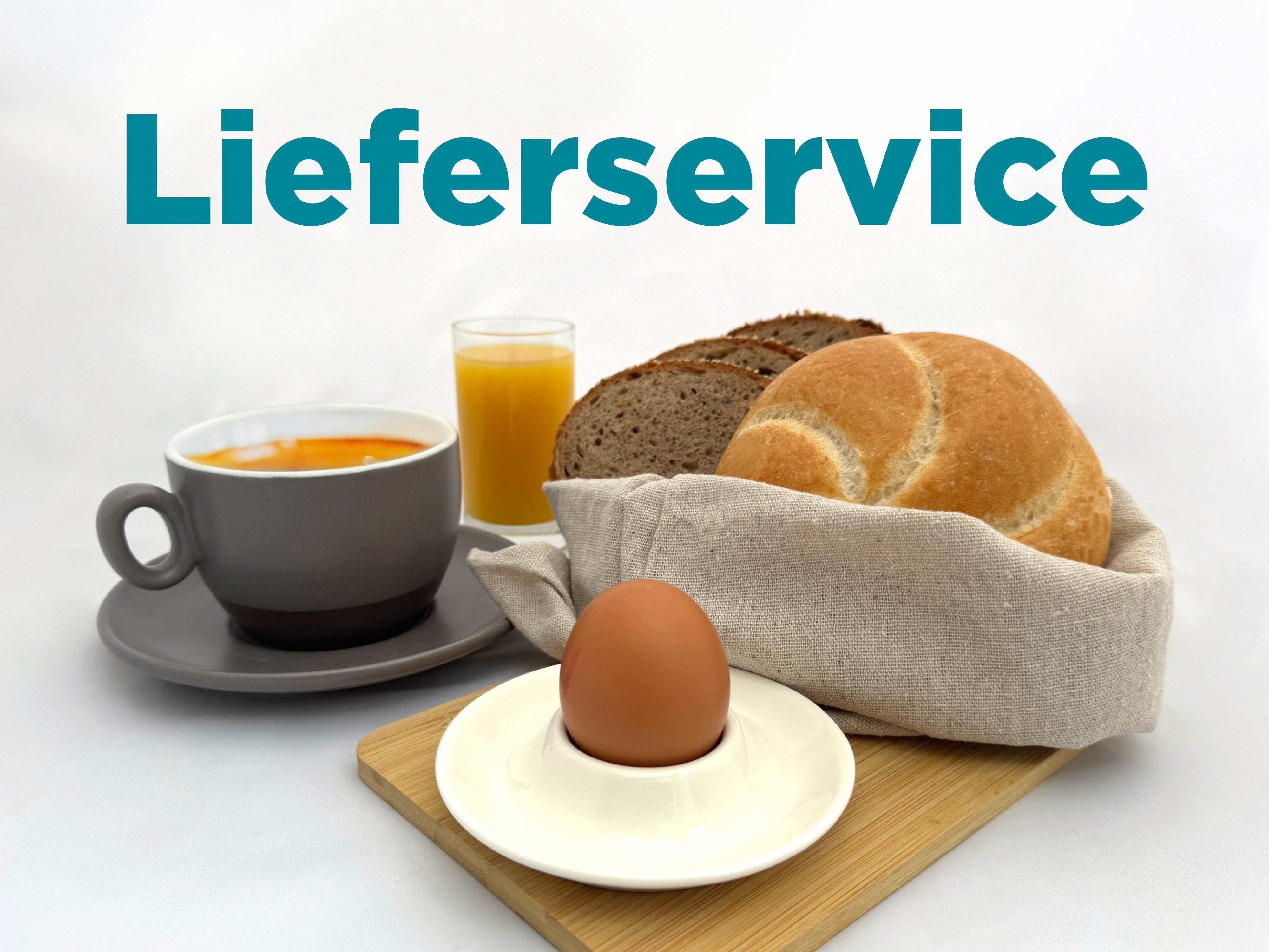 Breakfast with rolls, an egg, coffee, and orange juice on a table.