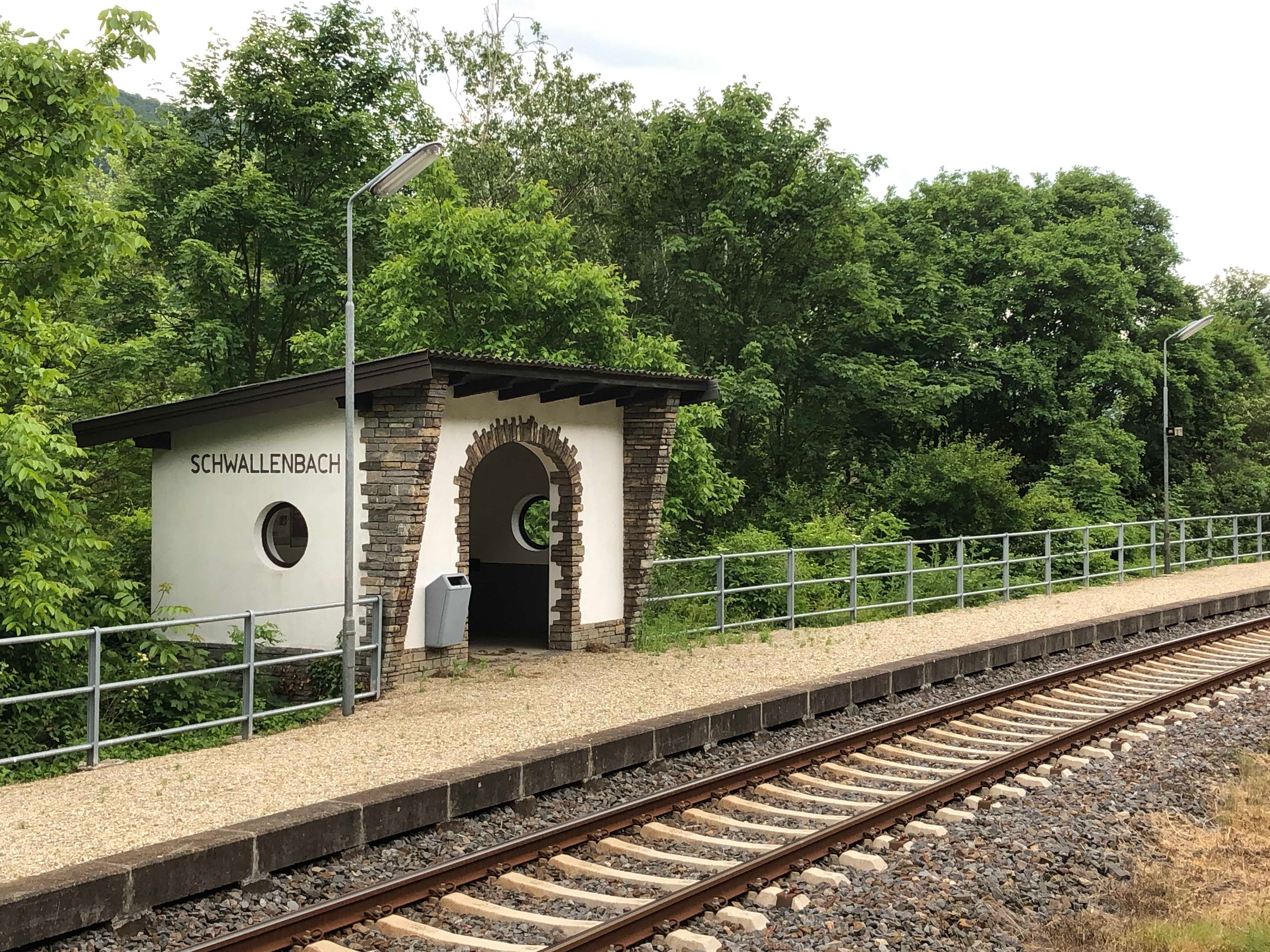 Small Schwallenbach station with tracks and surrounding nature.