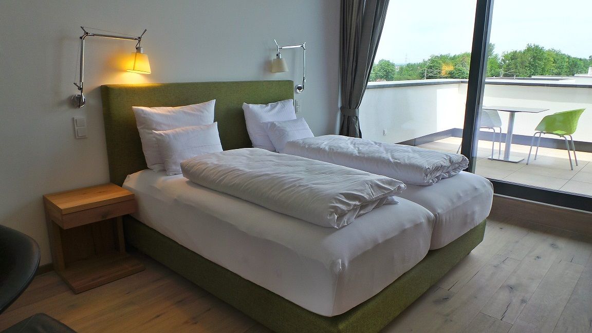 Modern bedroom with double bed and balcony.