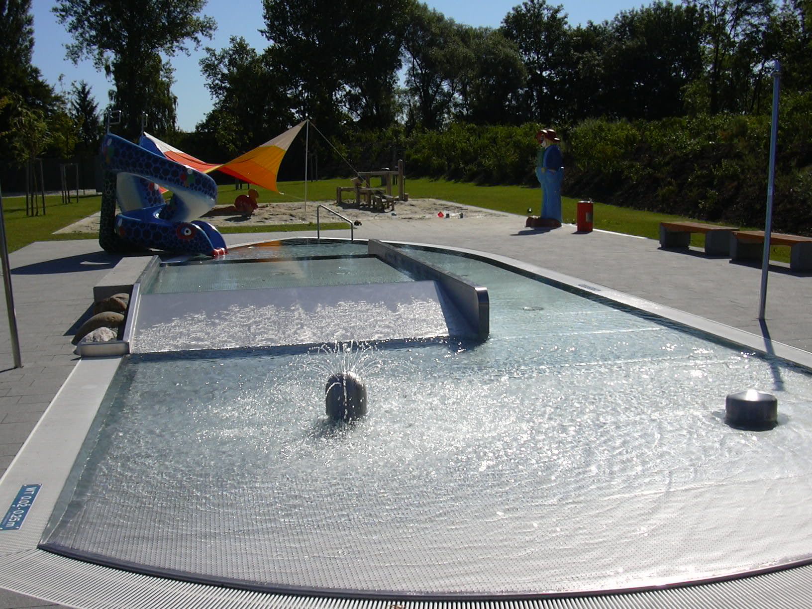 Children's pool with slide and outdoor water feature.