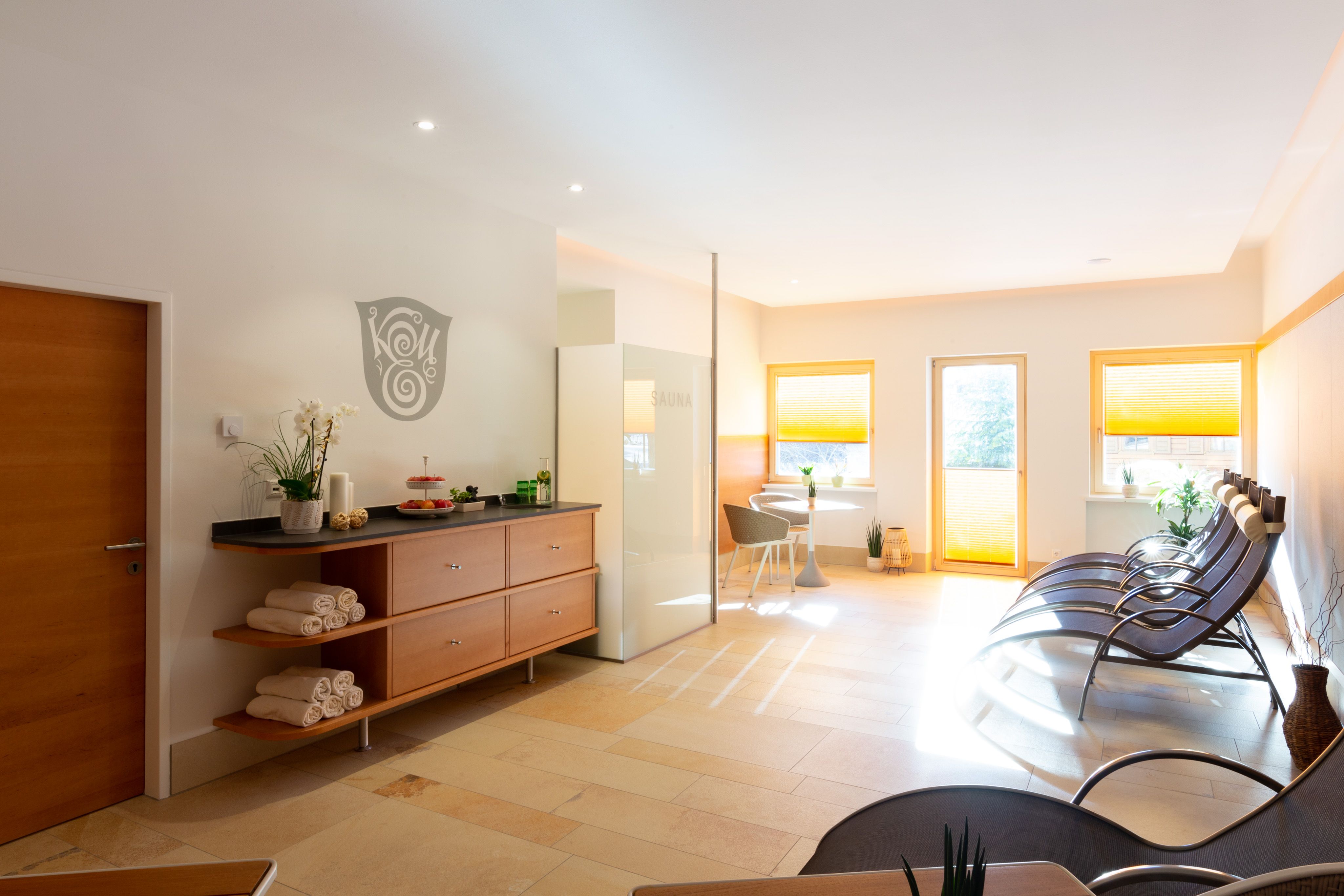 Modern wellness area with loungers, sauna and decoration.