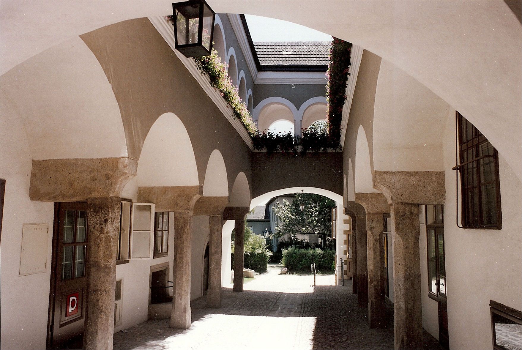 An arcaded courtyard with stone arches and flowers in the Hafnerhaus.