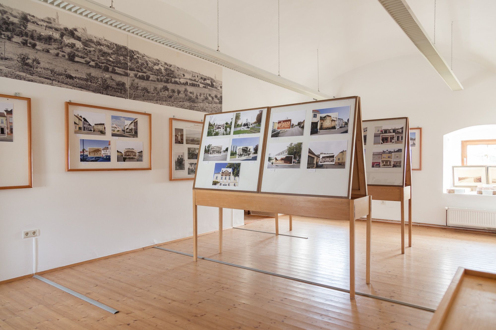 Interior view of a museum room with photo panels and historical pictures on the walls.