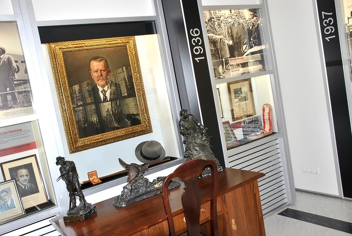 Interior view of a museum with paintings, sculptures and historical photos.