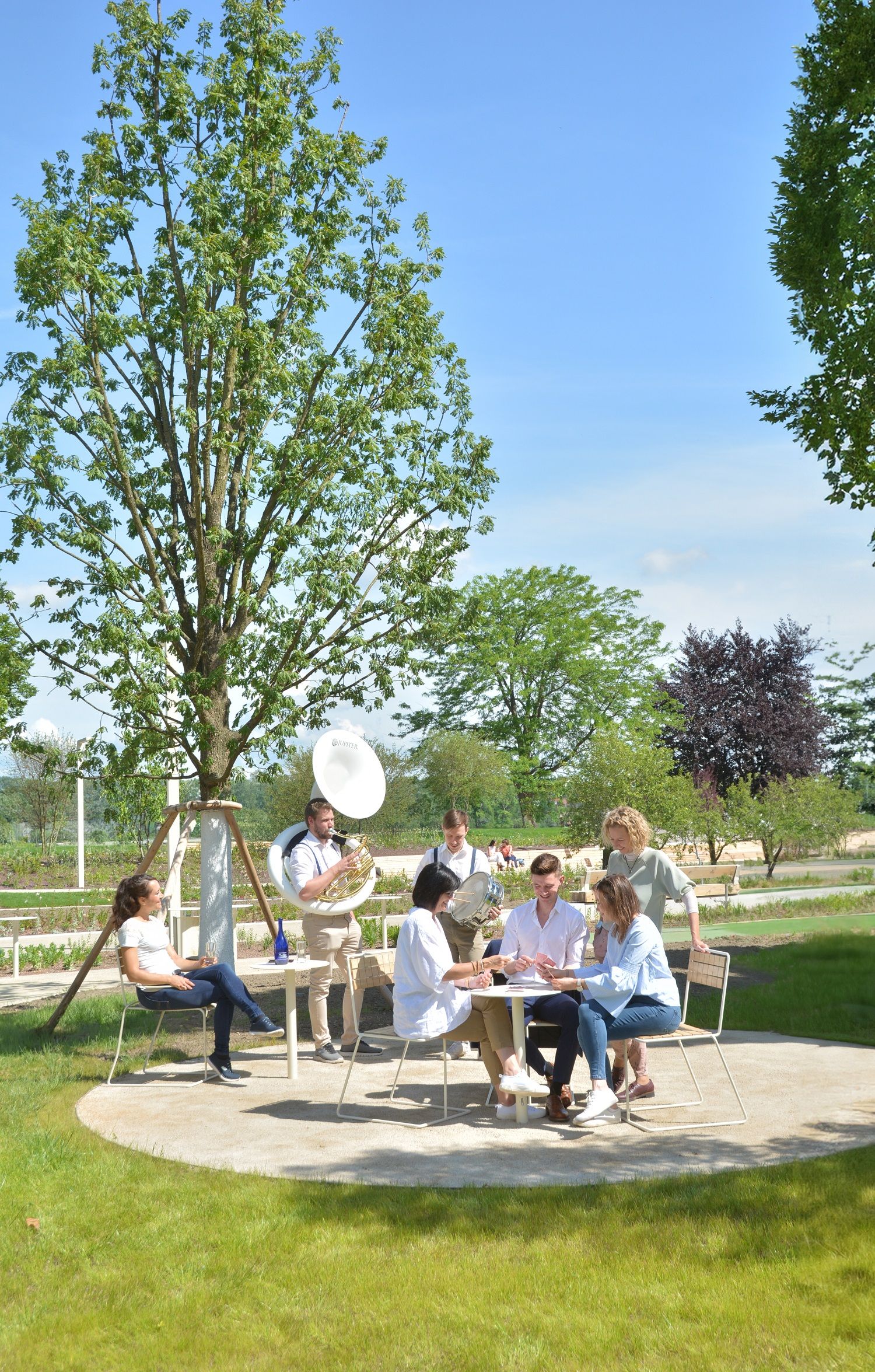 MEnschen group sitting chatting in the background band playing music 