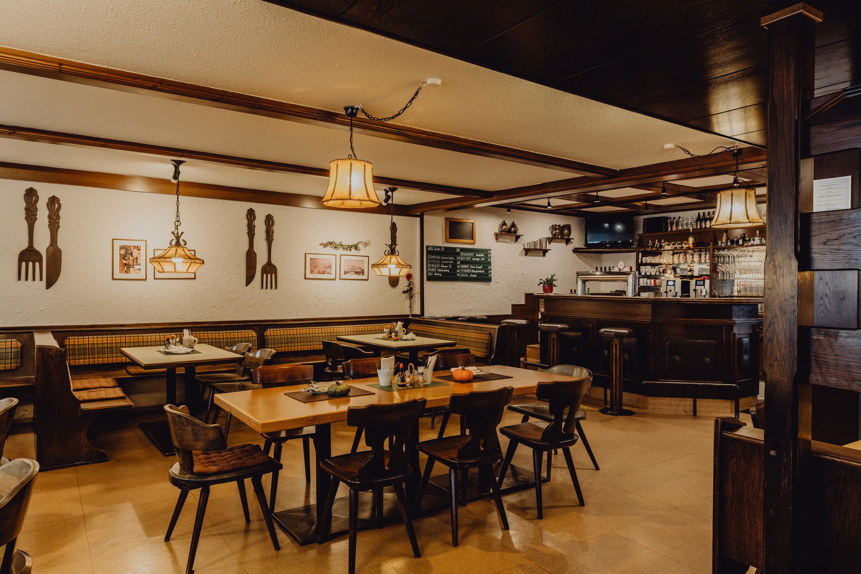 Cozy pub with wooden furniture, bar and decorative lamps.
