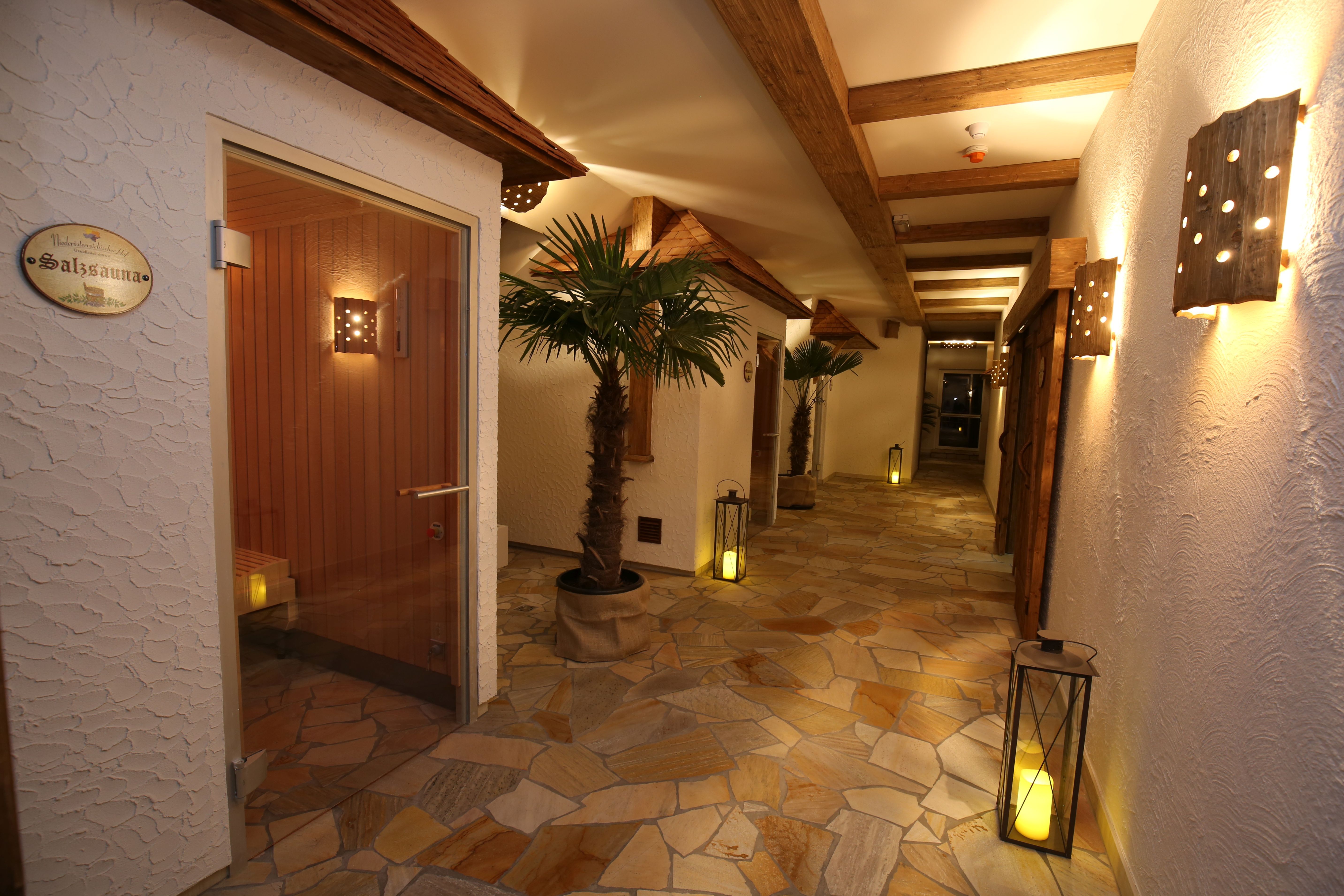 A spa hallway with salt sauna, palm trees, lanterns and wooden elements.