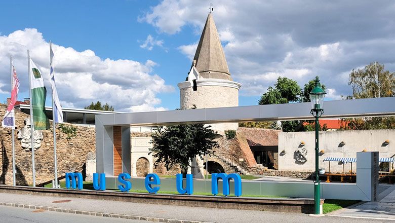 Entrance to the Horn Museum with modern lettering and historic tower in the background.