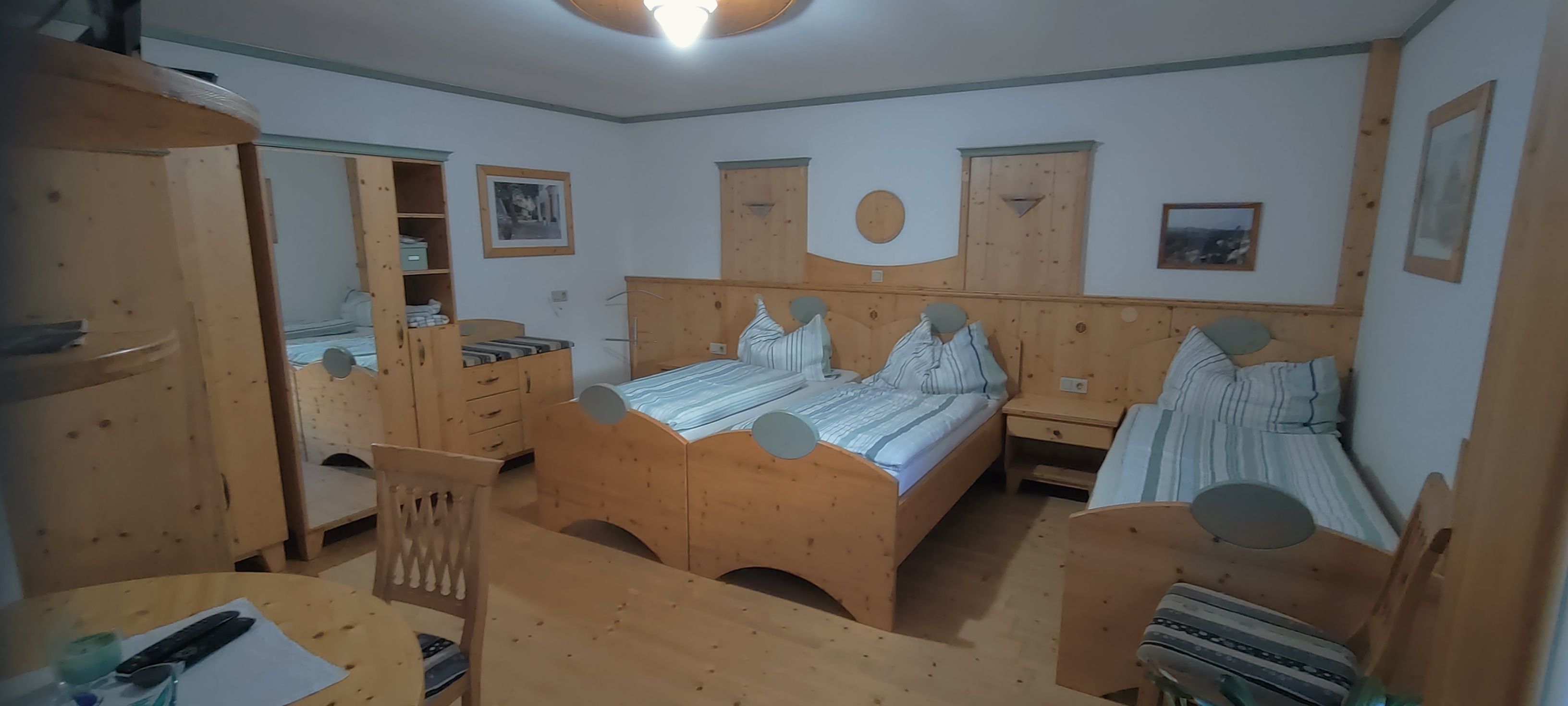 Cozy double room with wooden furniture and two single beds.