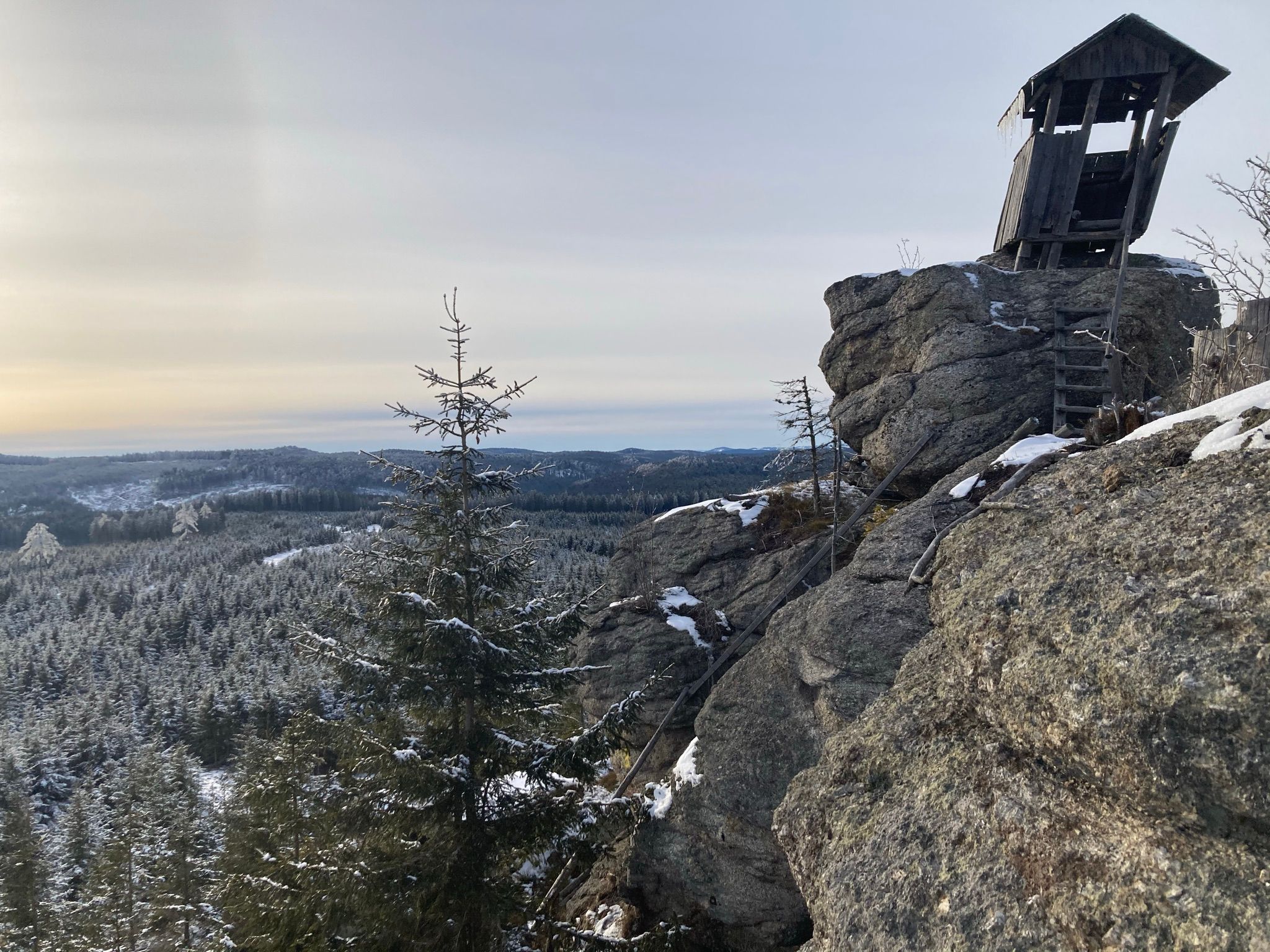 A high stand on a rock with a view of a snow-covered forest landscape.