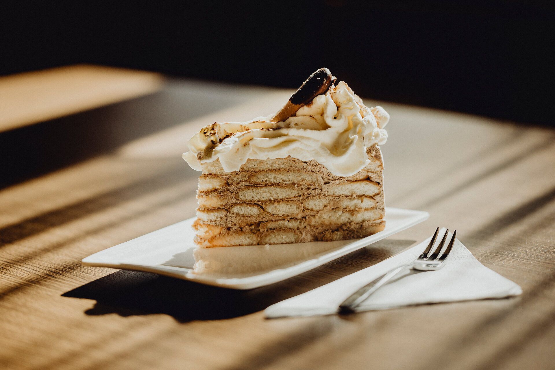 Enjoy a slice of the delicious Malakoff cake, served in the warm atmosphere of Gasthof Pichler. The tender sponge cake and creamy filling invite you to take a break and experience the beauty of the Vienna Alps.