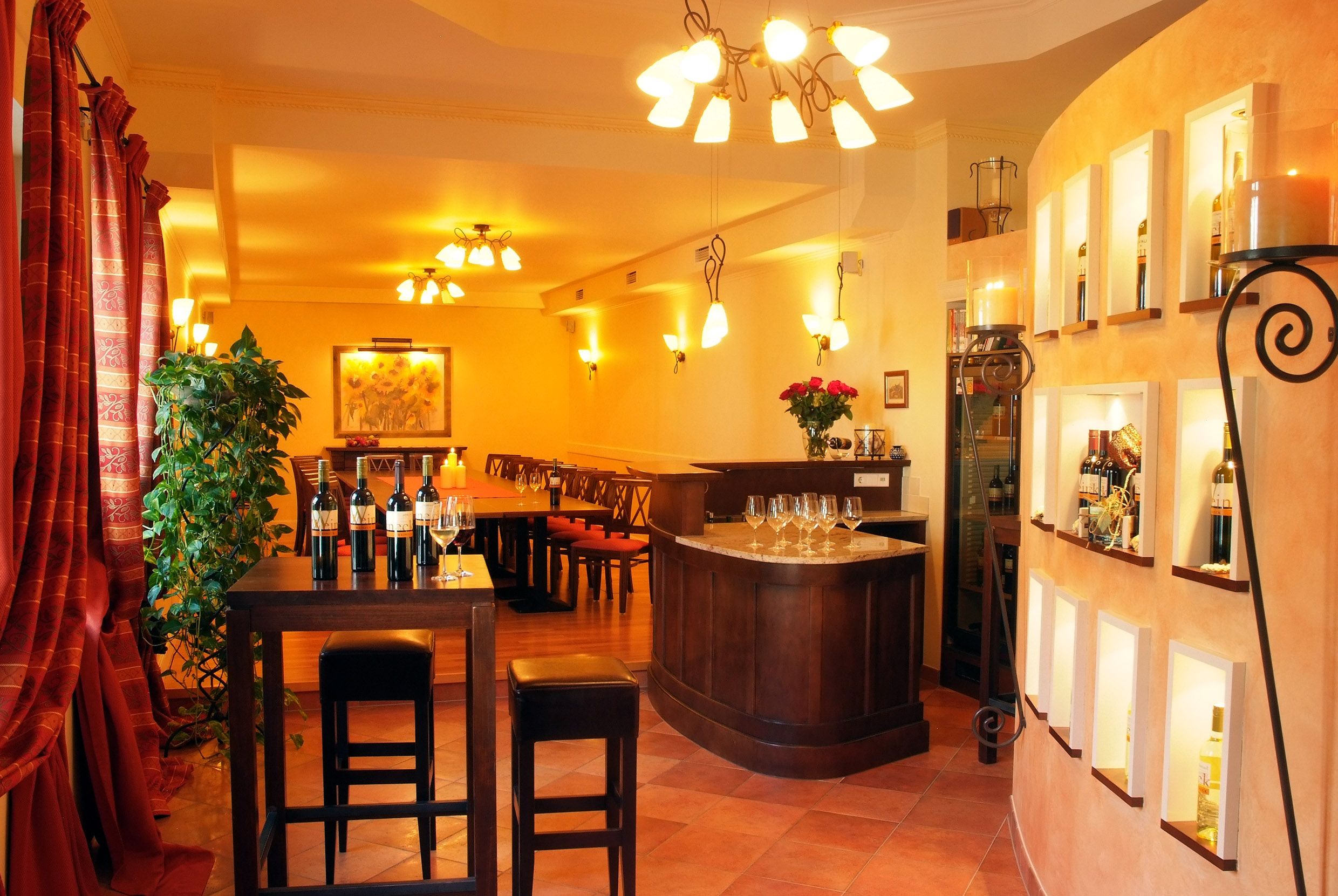 An elegant tasting room with wine bottles, glasses and stylish lighting.