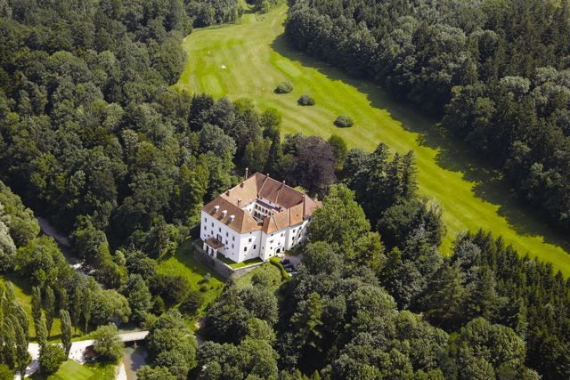 Aerial view of Ernegg Castle surrounded by woods and meadows.