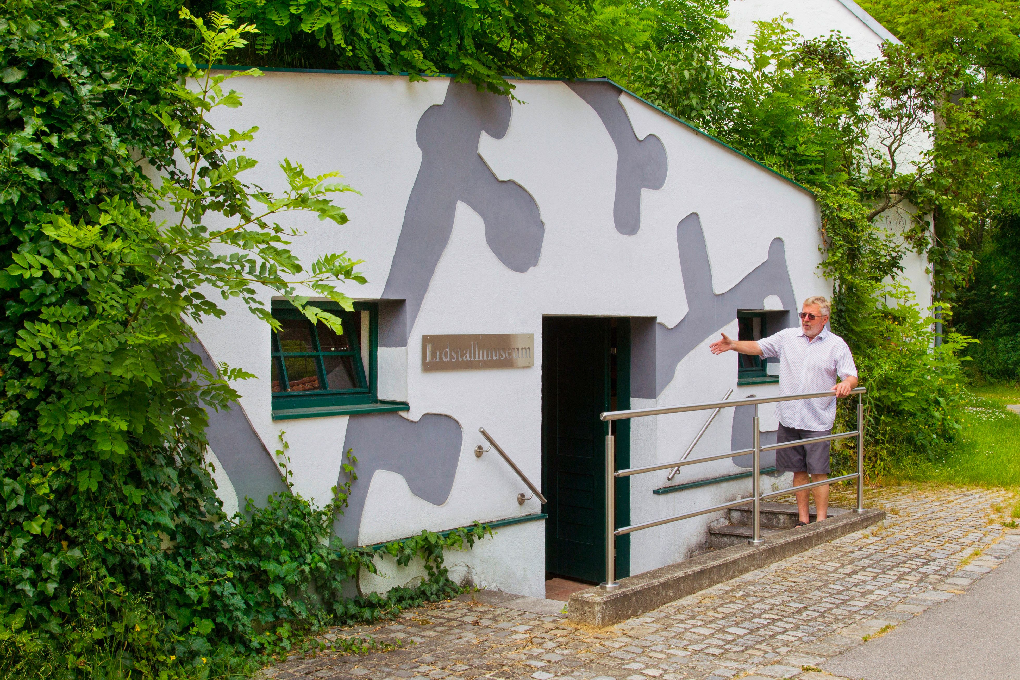 Entrance to the Erdstallmuseum Althöflein with a man showing the door.