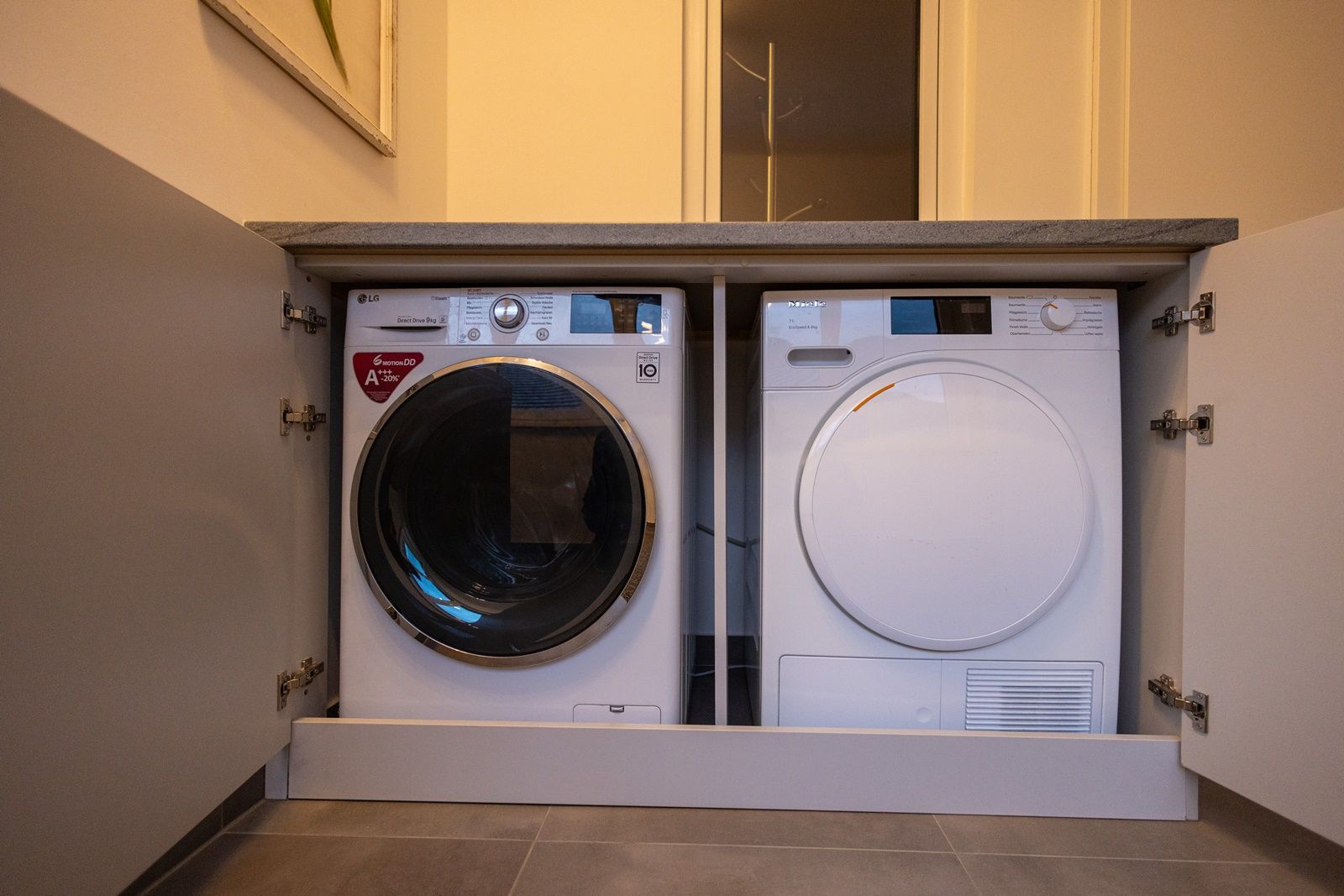 Washing machine and dryer built into a cupboard.