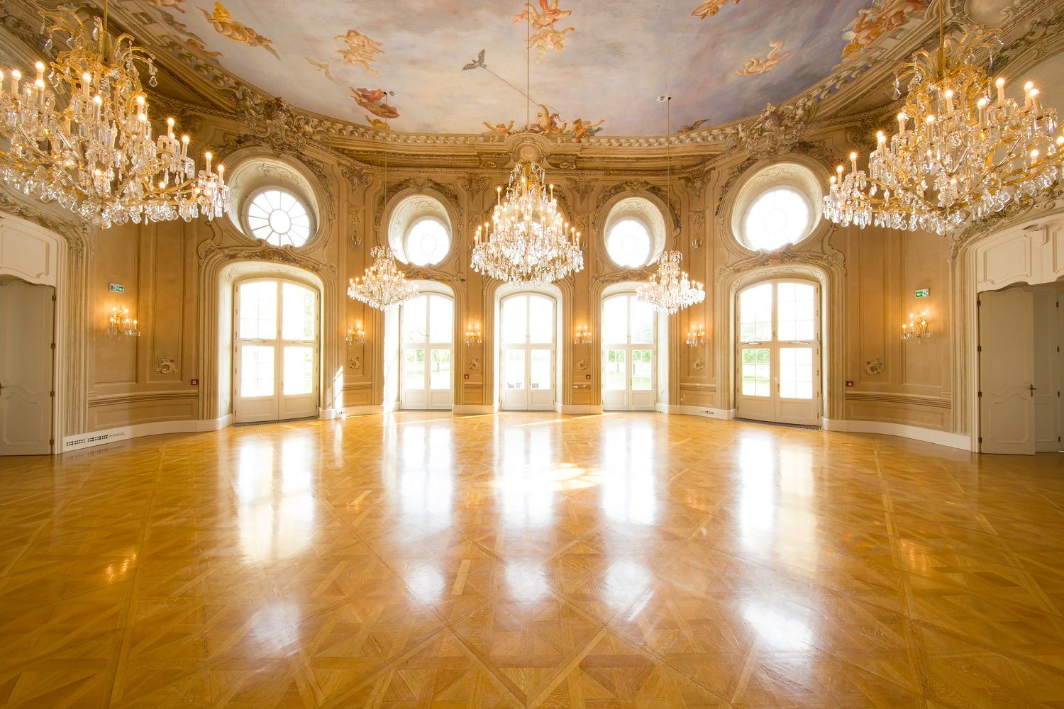 Elegant ballroom with chandeliers and painted ceiling at the Conference Center Laxenburg.