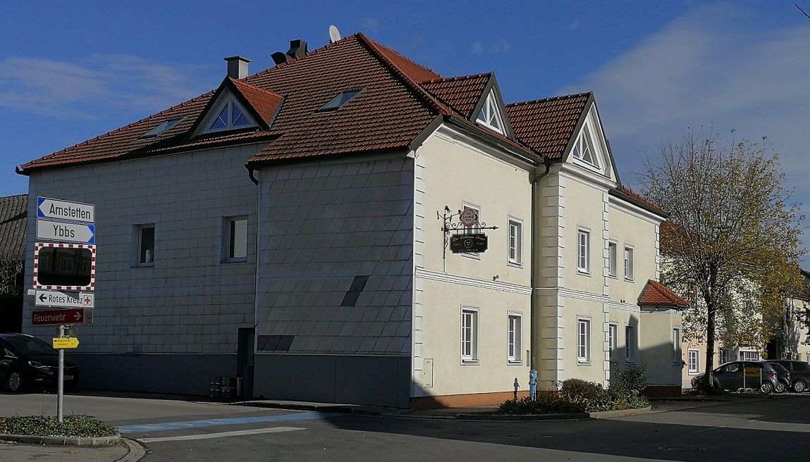 A two-storey building with a red roof and a sign saying 'Gasthaus Pitzl'.
