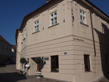 Exterior view of the Hotel Ur-Wachau with beige building and blue sky.