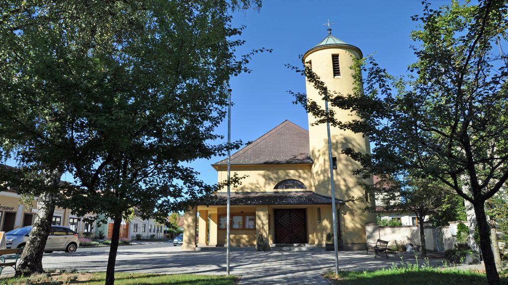 St. Anthony's Church in Bad Erlach with yellow tower and trees in the foreground.