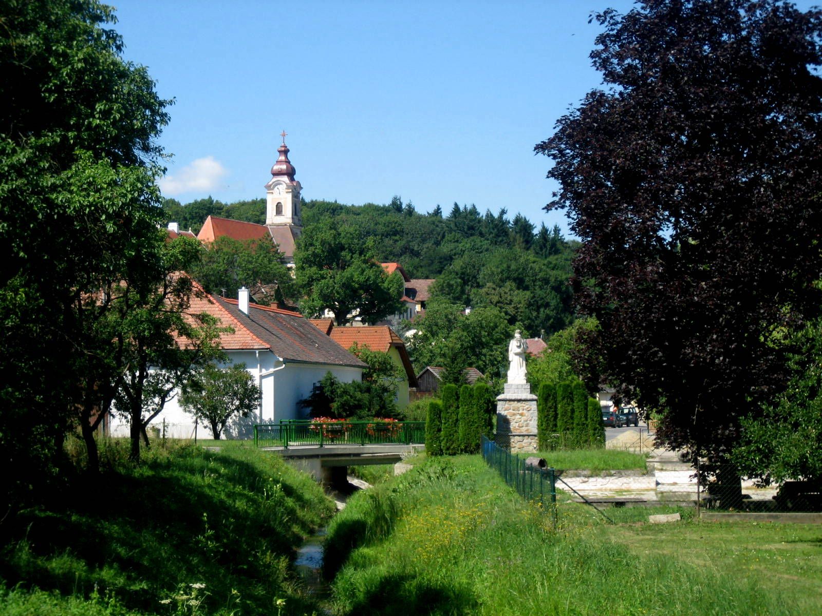 Landscape with church and statue in a village.
