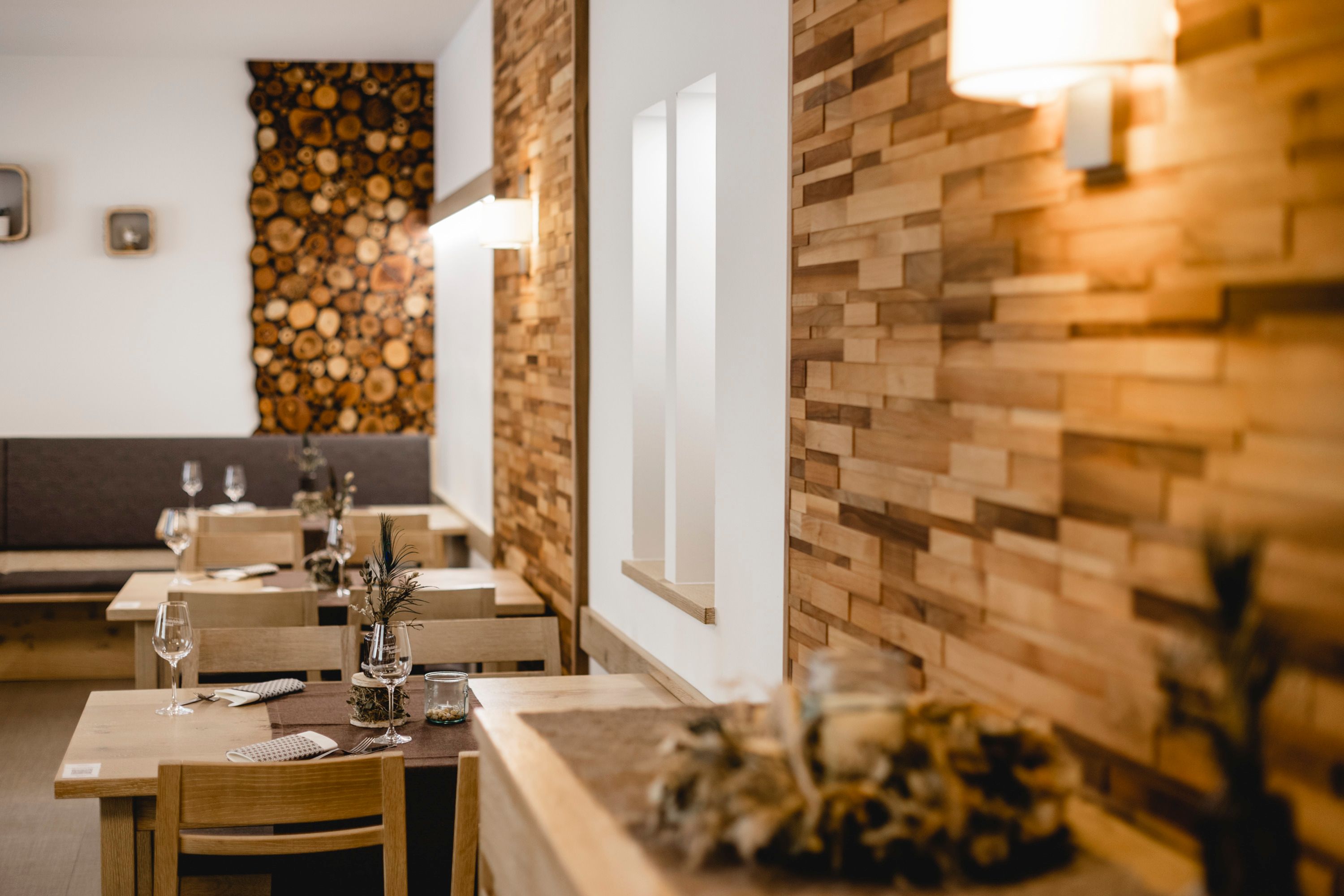 Cozy restaurant with wooden walls and decorated tables.