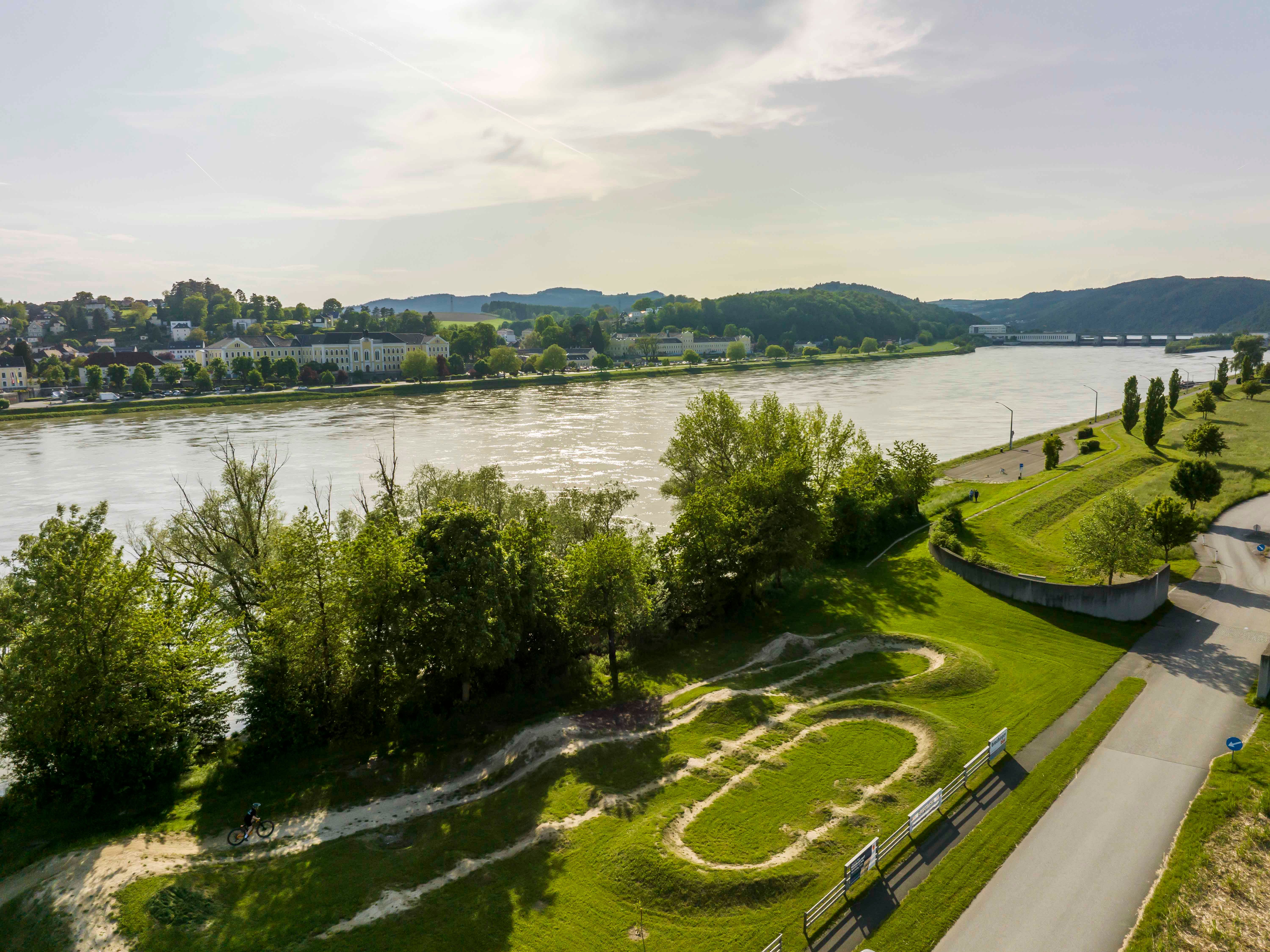 Aerial view of the Persenbeug-Gottsdorf bike arena with river and surrounding landscape.