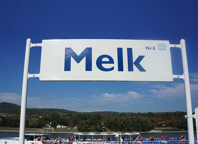 Sign with the inscription 'Melk Nr. 8' in front of a blue sky.