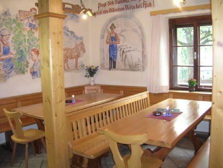 Cozy wine bar with wooden furniture and murals.