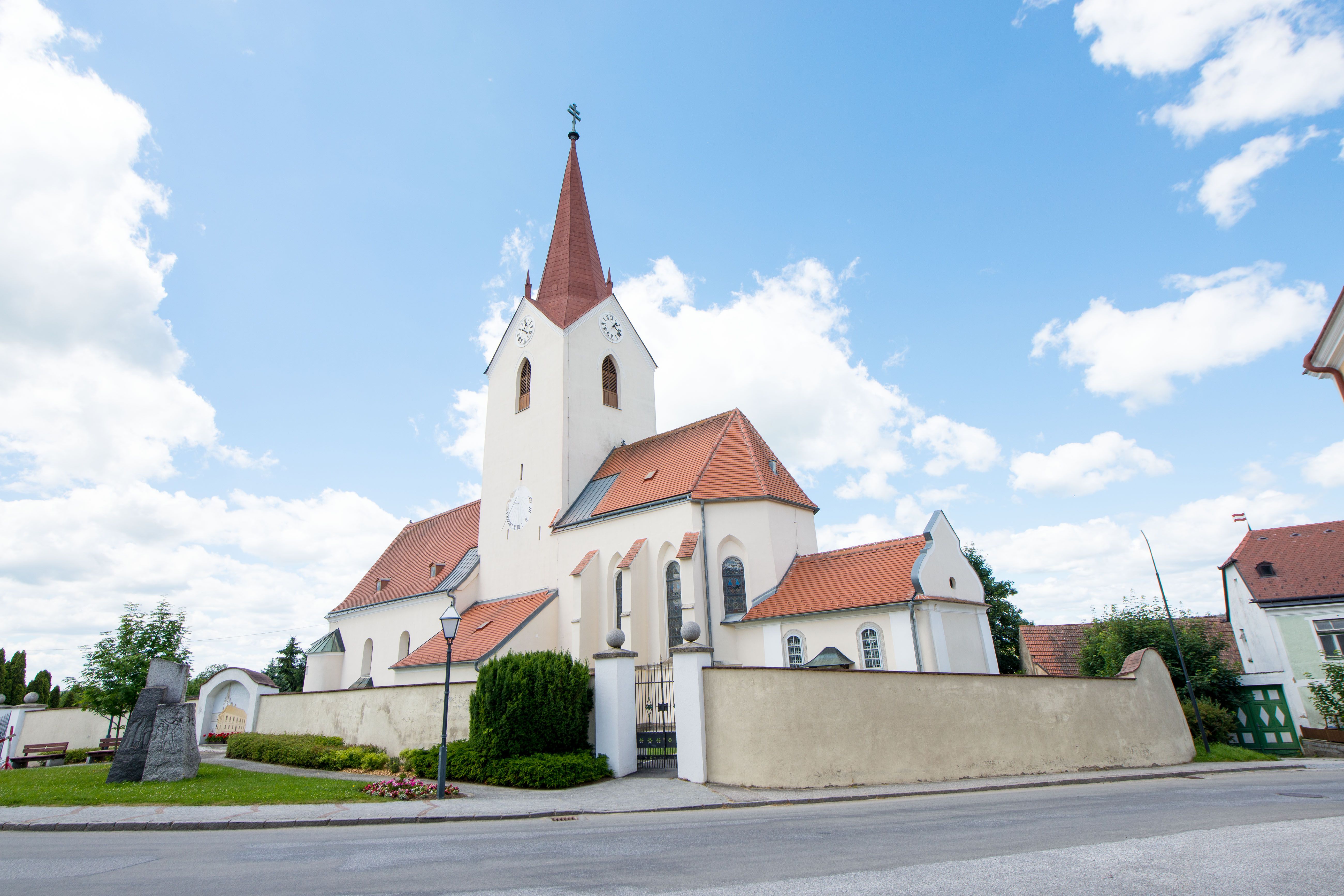 Church in Schweiggers with red roof and tower against a blue sky.