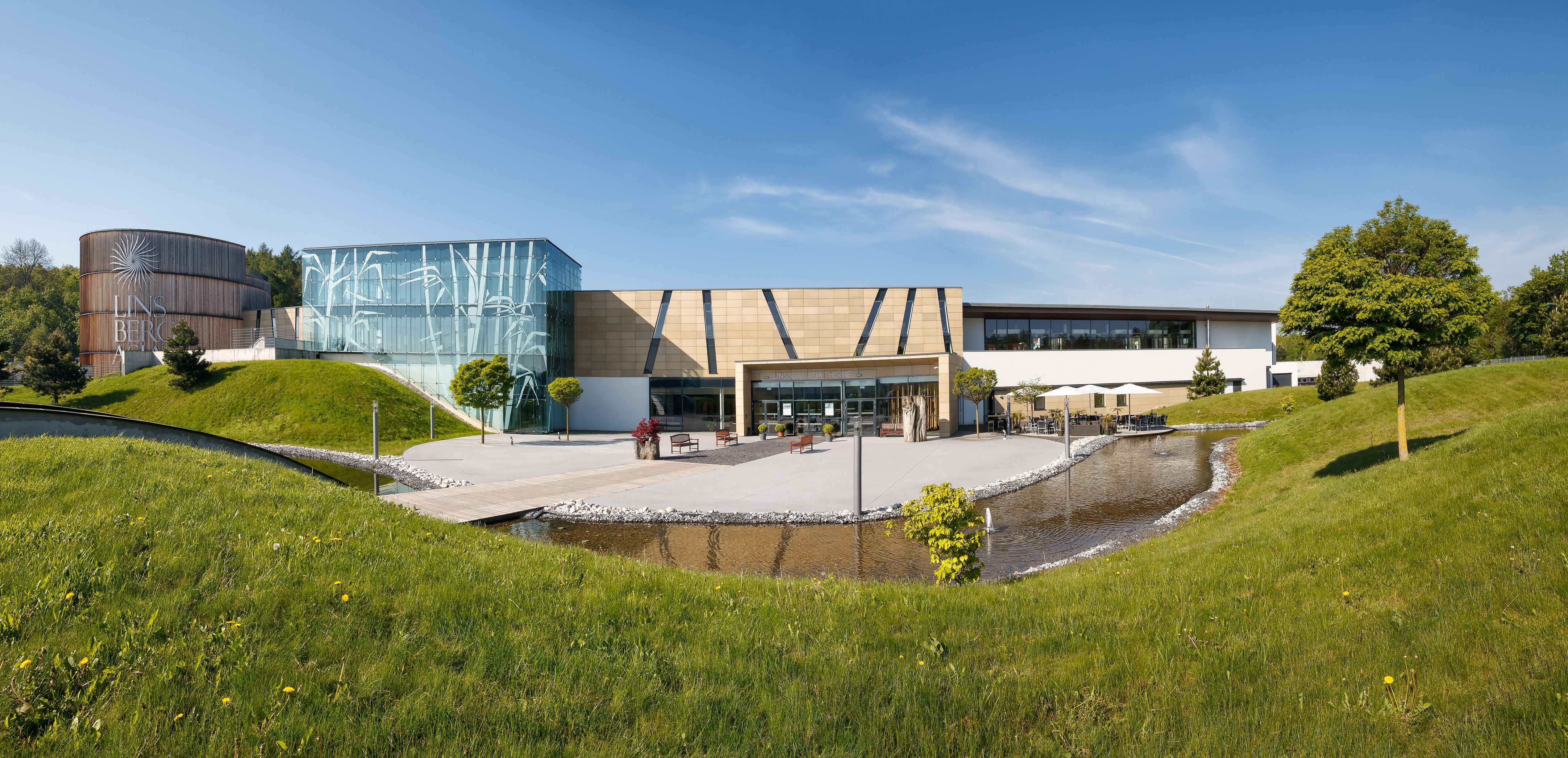 Exterior view of the Linsberg Asia Therme with modern architecture and green spaces.