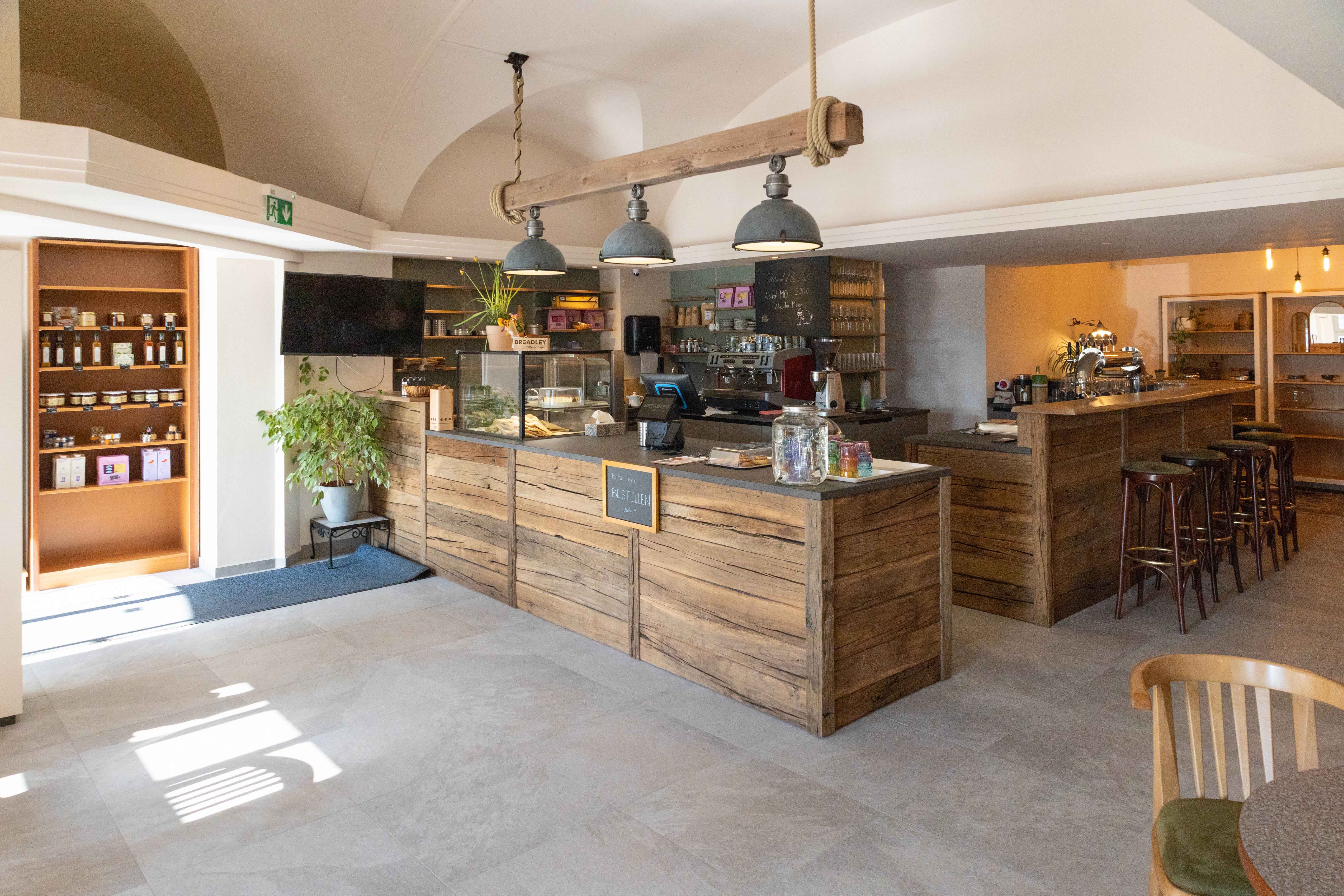 Interior view of a cozy café with wooden furniture and counter.
