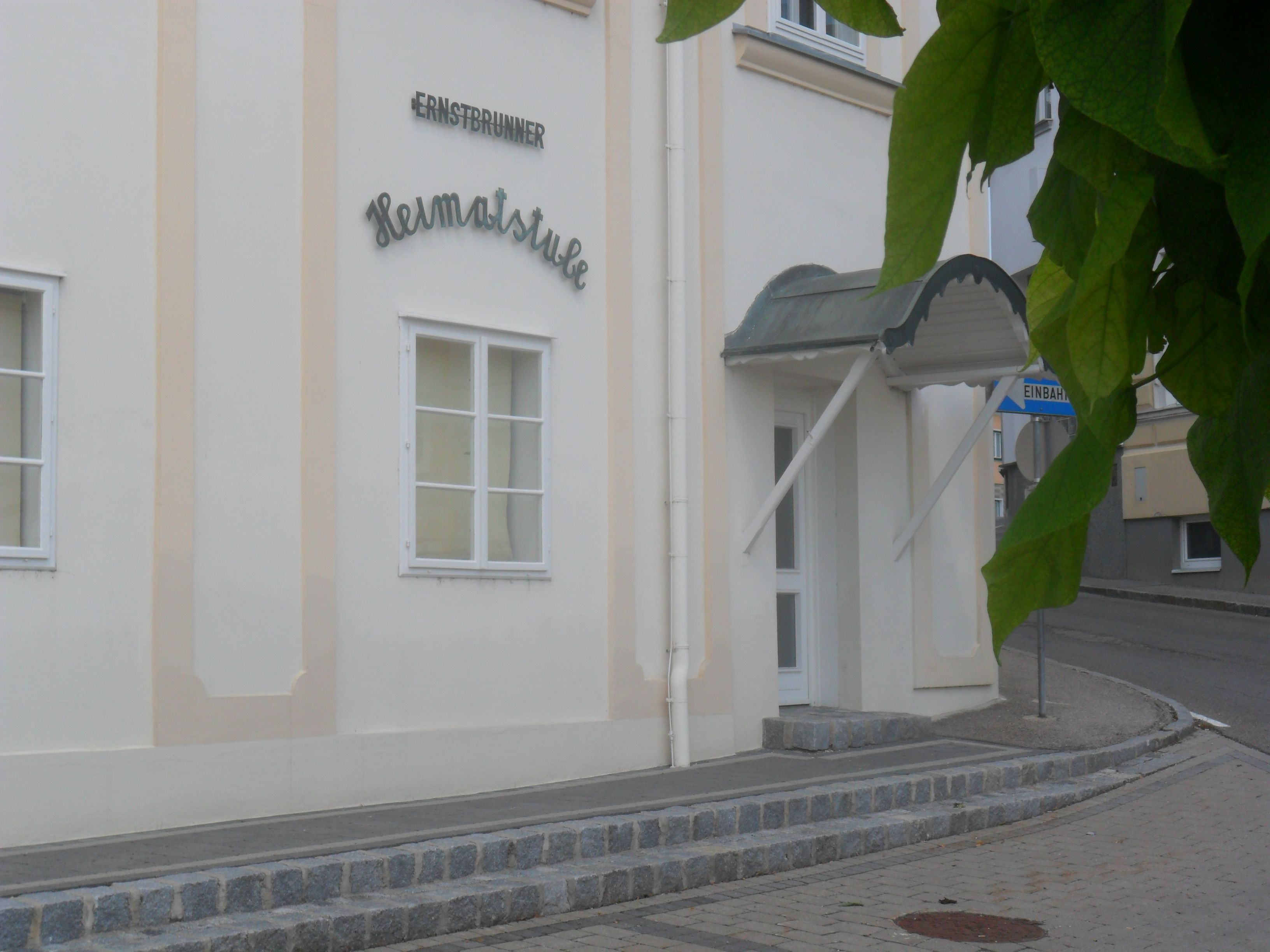 Entrance to the Ernstbrunn Heimatstube with canopy and street sign.