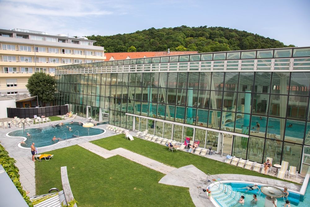 Exterior view of the Römertherme Baden with pool and glass façade.