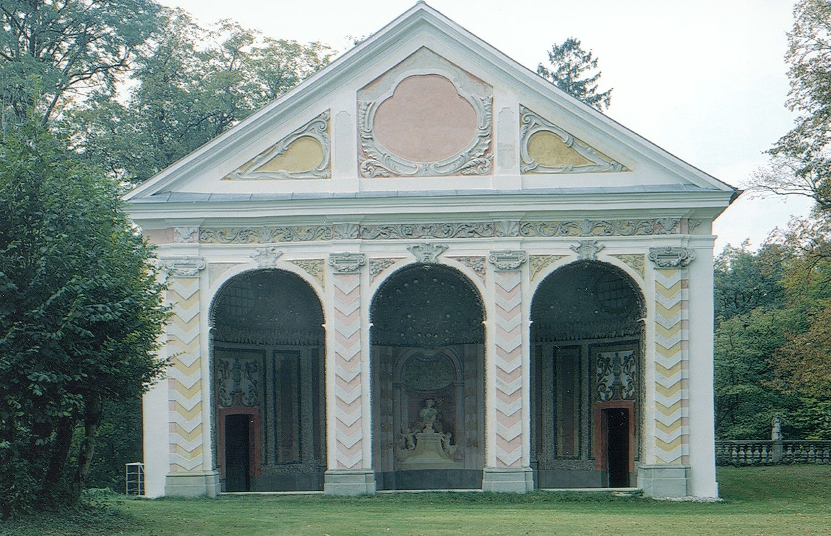 Baroque building with three arches and decorated facades.