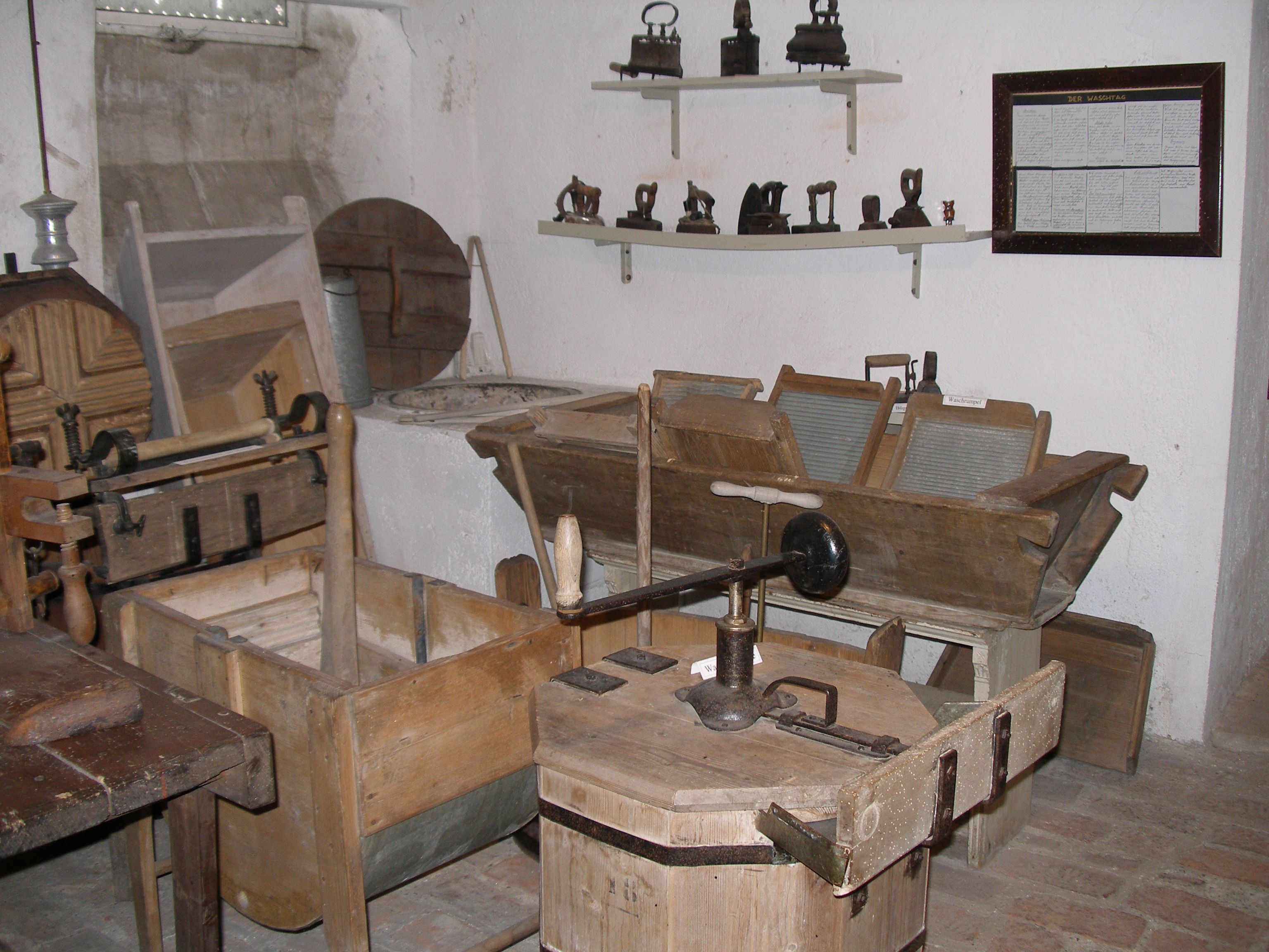 A room with old household appliances such as washboards and irons.