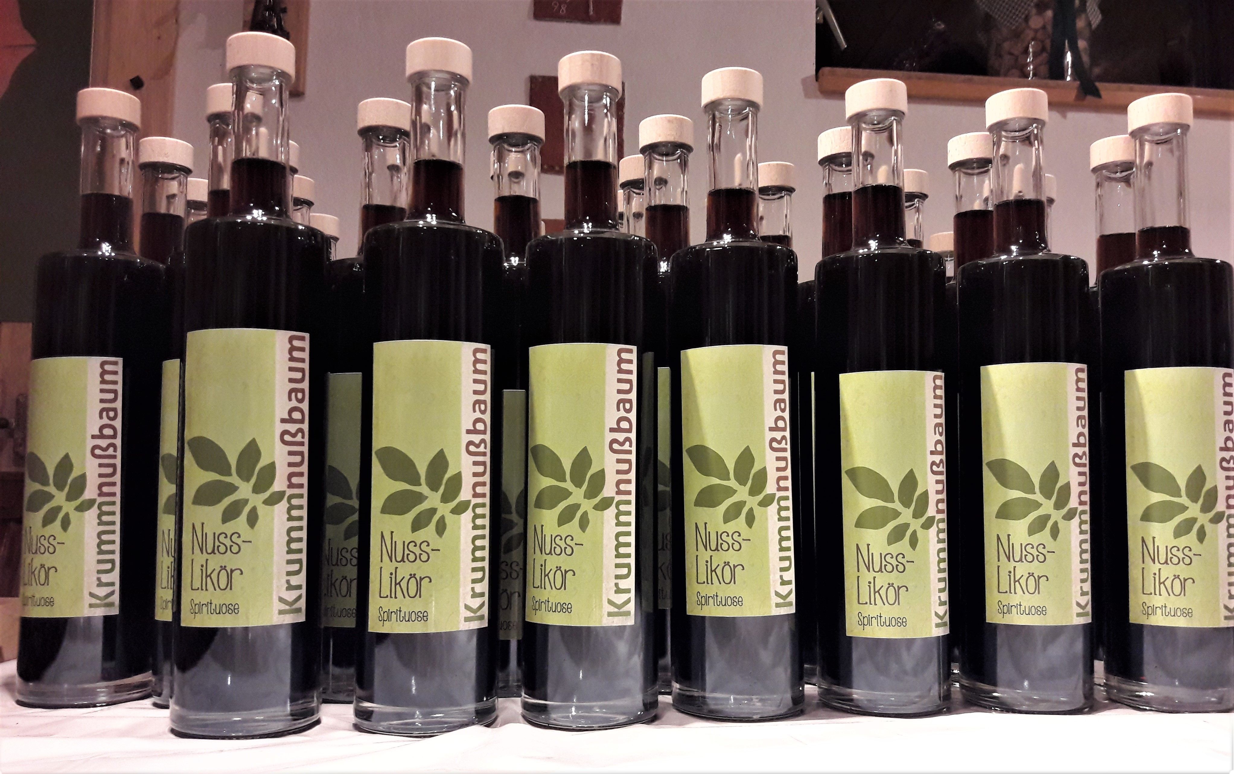 Row of bottles with nut liqueur and green labels.