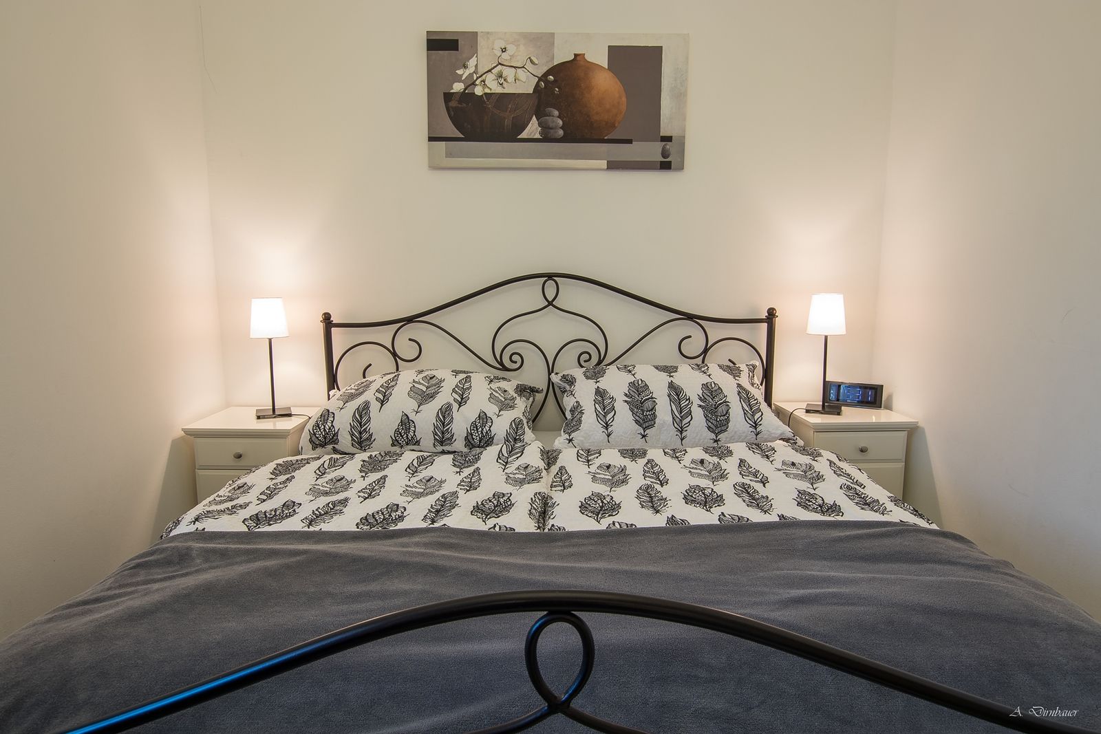 Bedroom with double bed, two bedside tables and lamps.